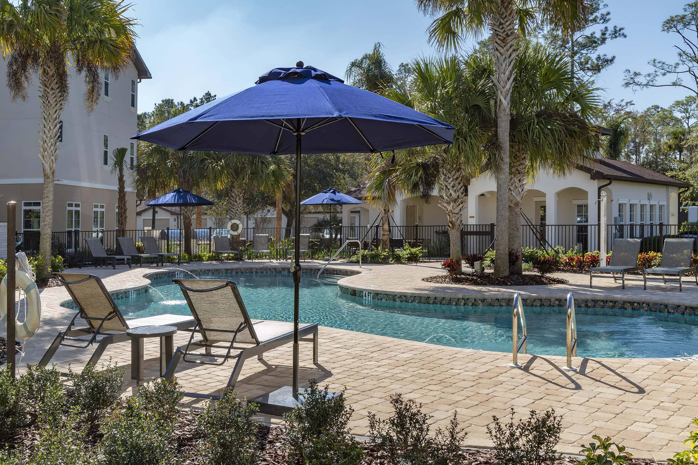 a group of lawn chairs sitting next to a pool of water