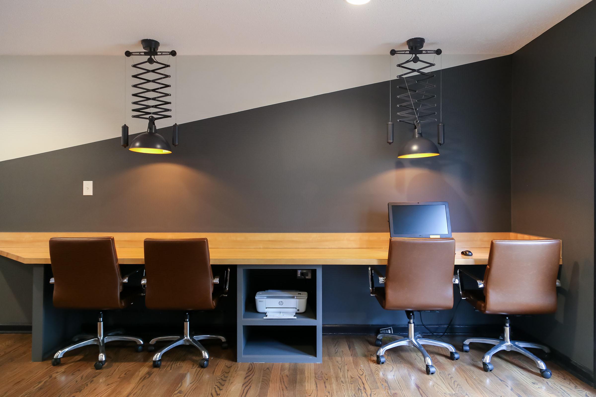 a desk with a computer and a chair in a room