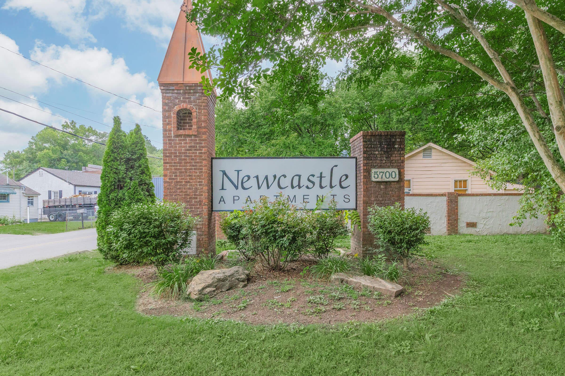 a large brick building with grass in front of a house