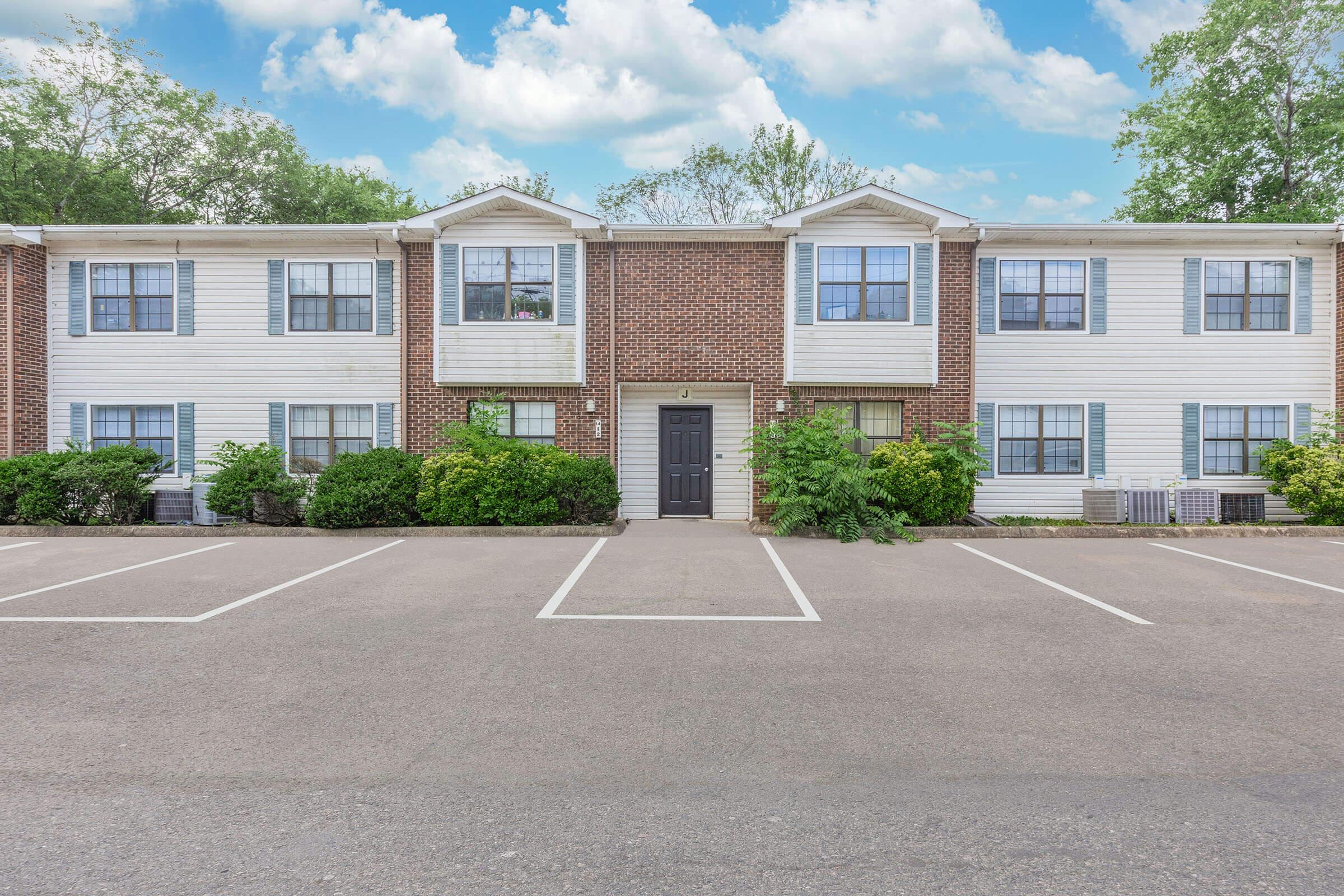 an empty parking lot in front of a house