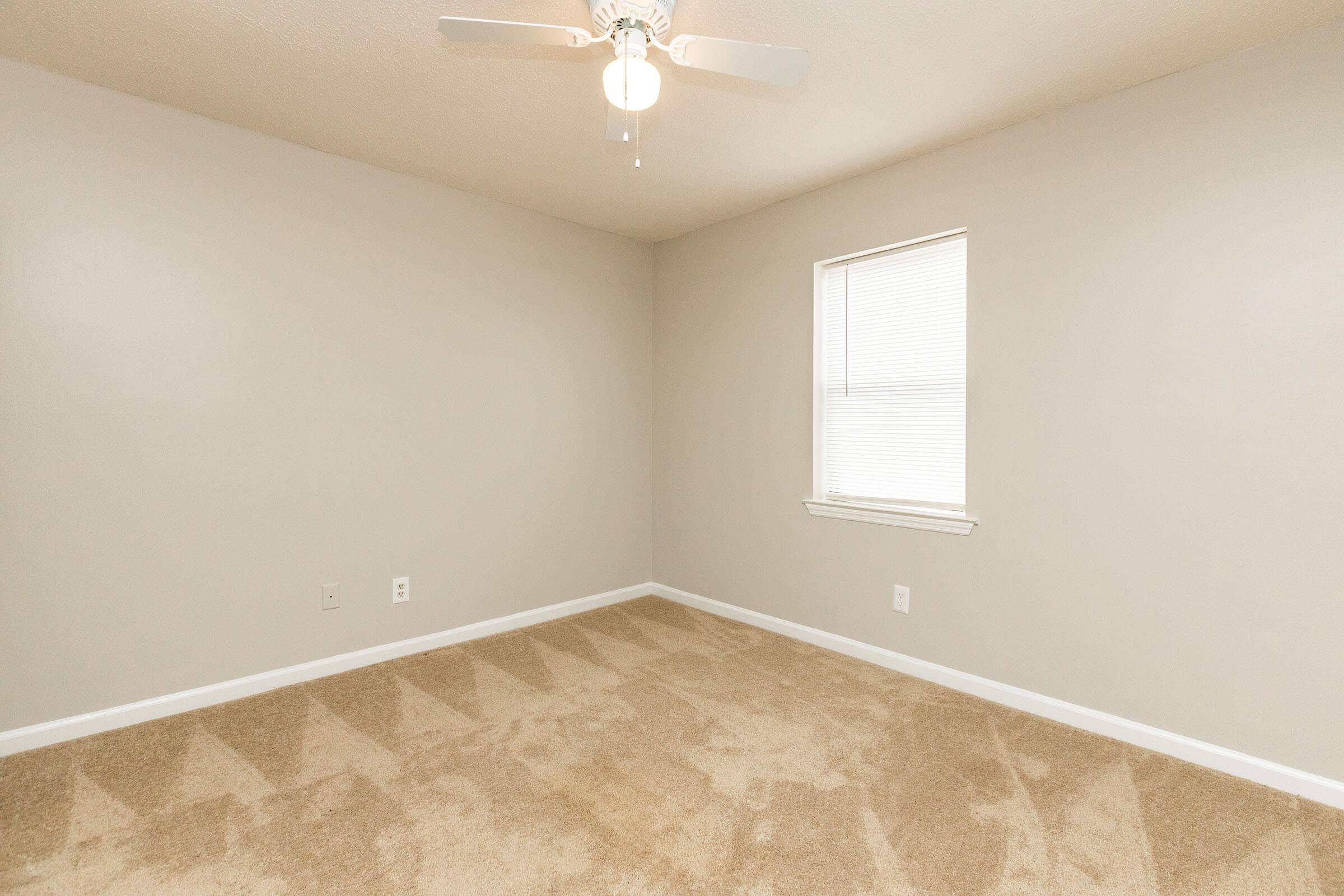 a large empty room with a sink and a mirror