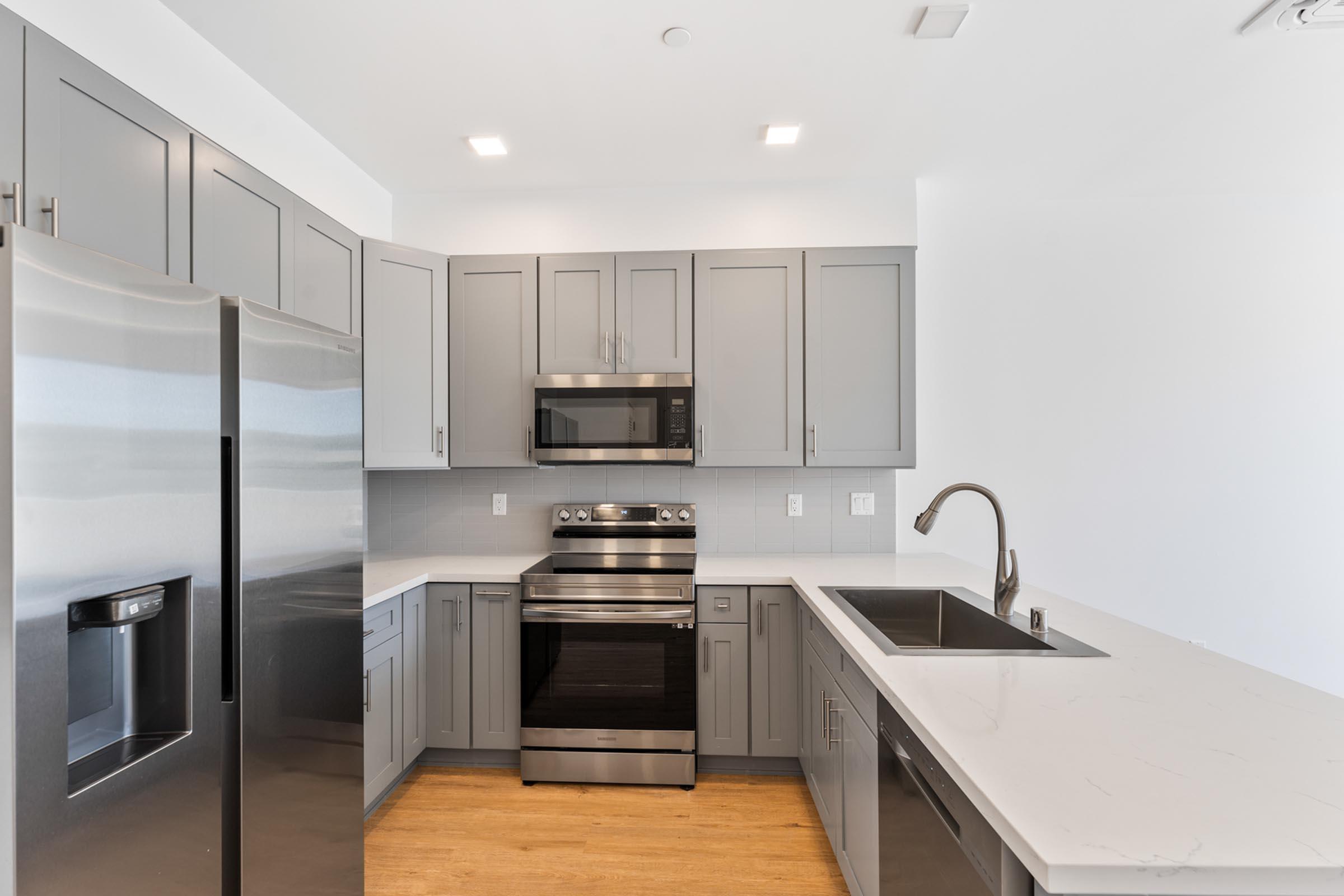 a large kitchen with stainless steel appliances and wooden cabinets