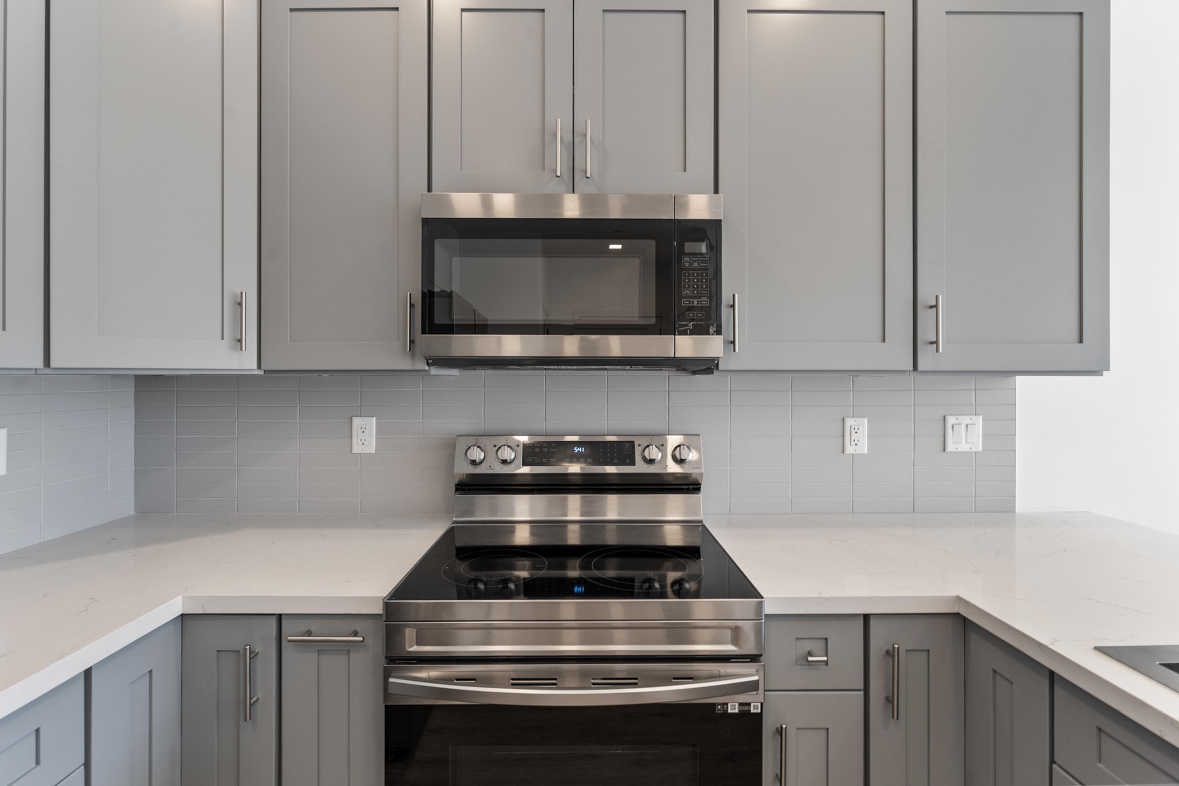 a kitchen with a stove a sink and a microwave oven on a counter