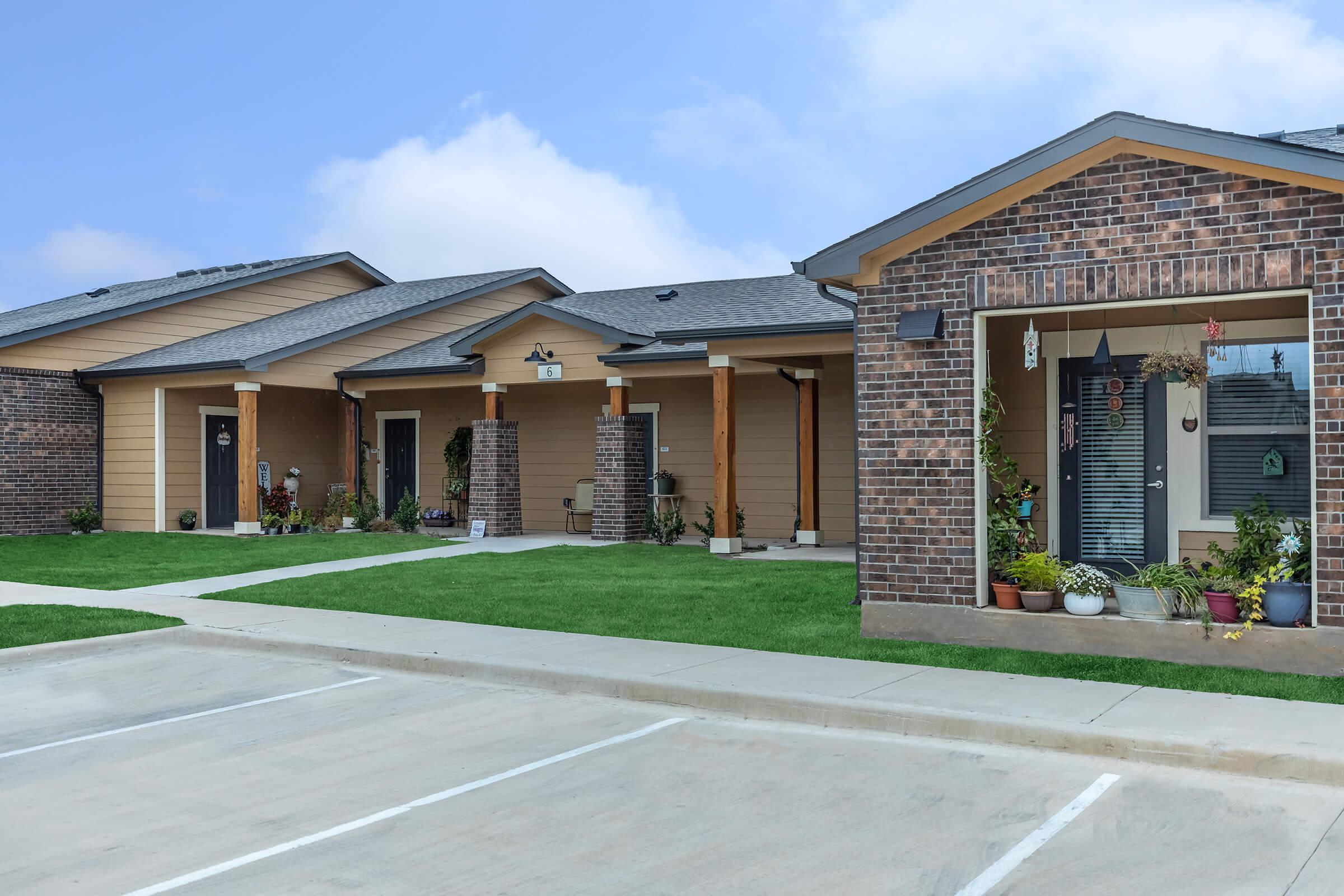 a large brick building with grass in front of a house