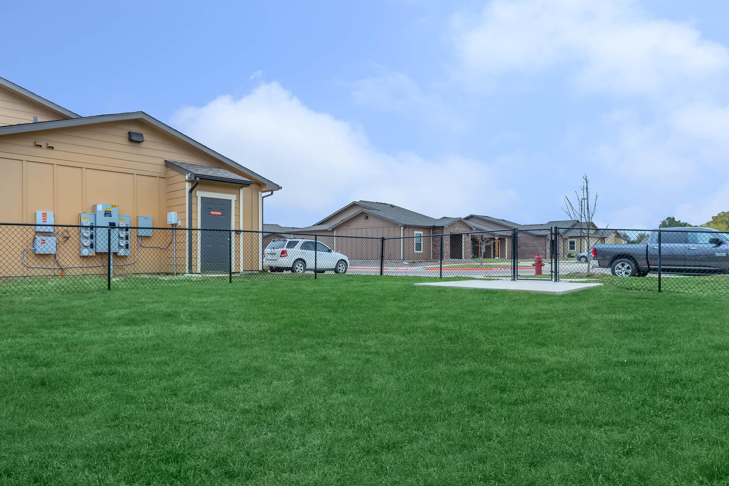 a large green field in front of a house