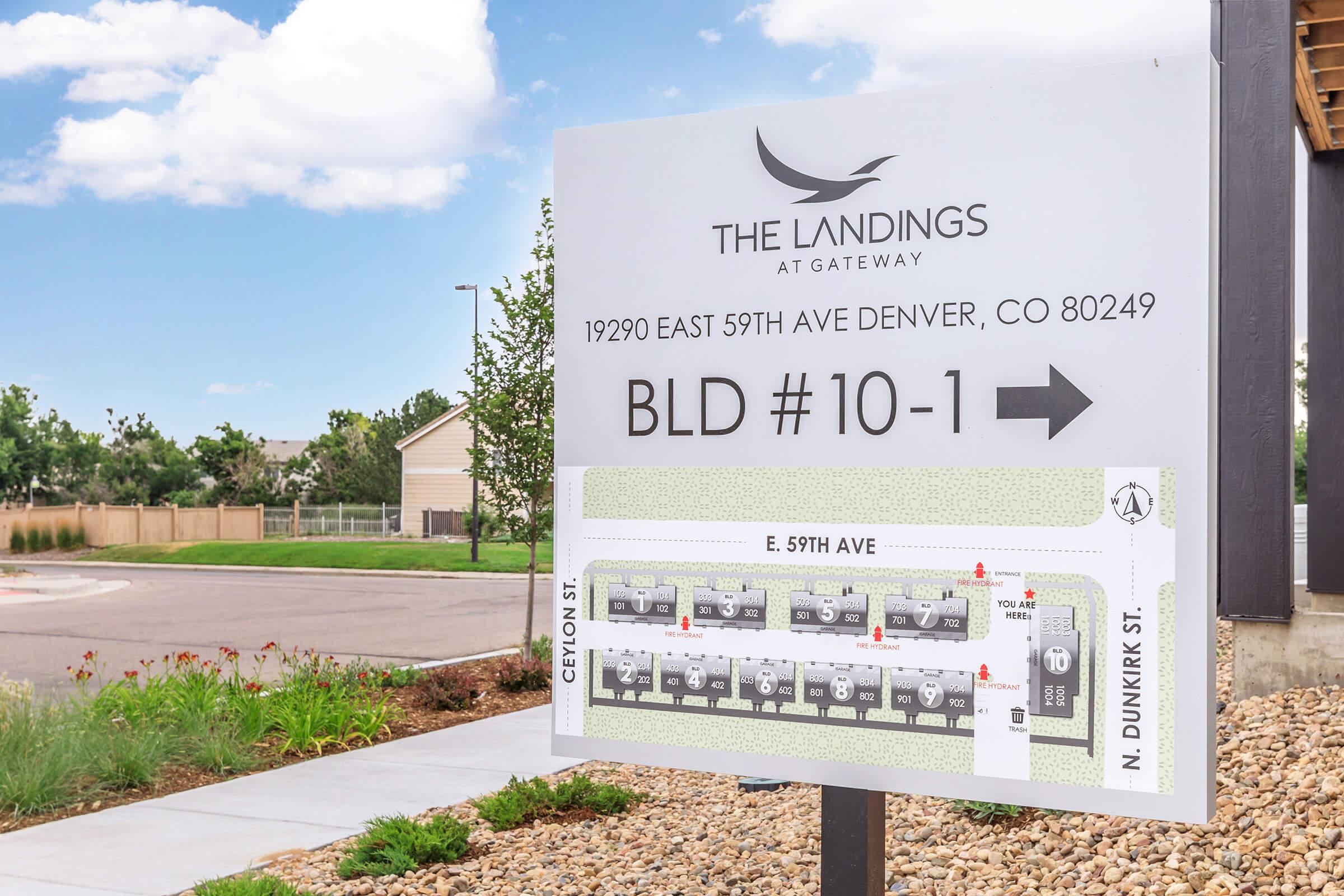 Signage for The Landings at Gateway, located at 19290 East 59th Ave, Denver, CO 80249. The sign indicates Building #10-1 with an arrow pointing right. A map shows nearby streets, including Ceylon Street and N. Dunkirk Street, along with the layout of the property. Clear blue skies in the background.