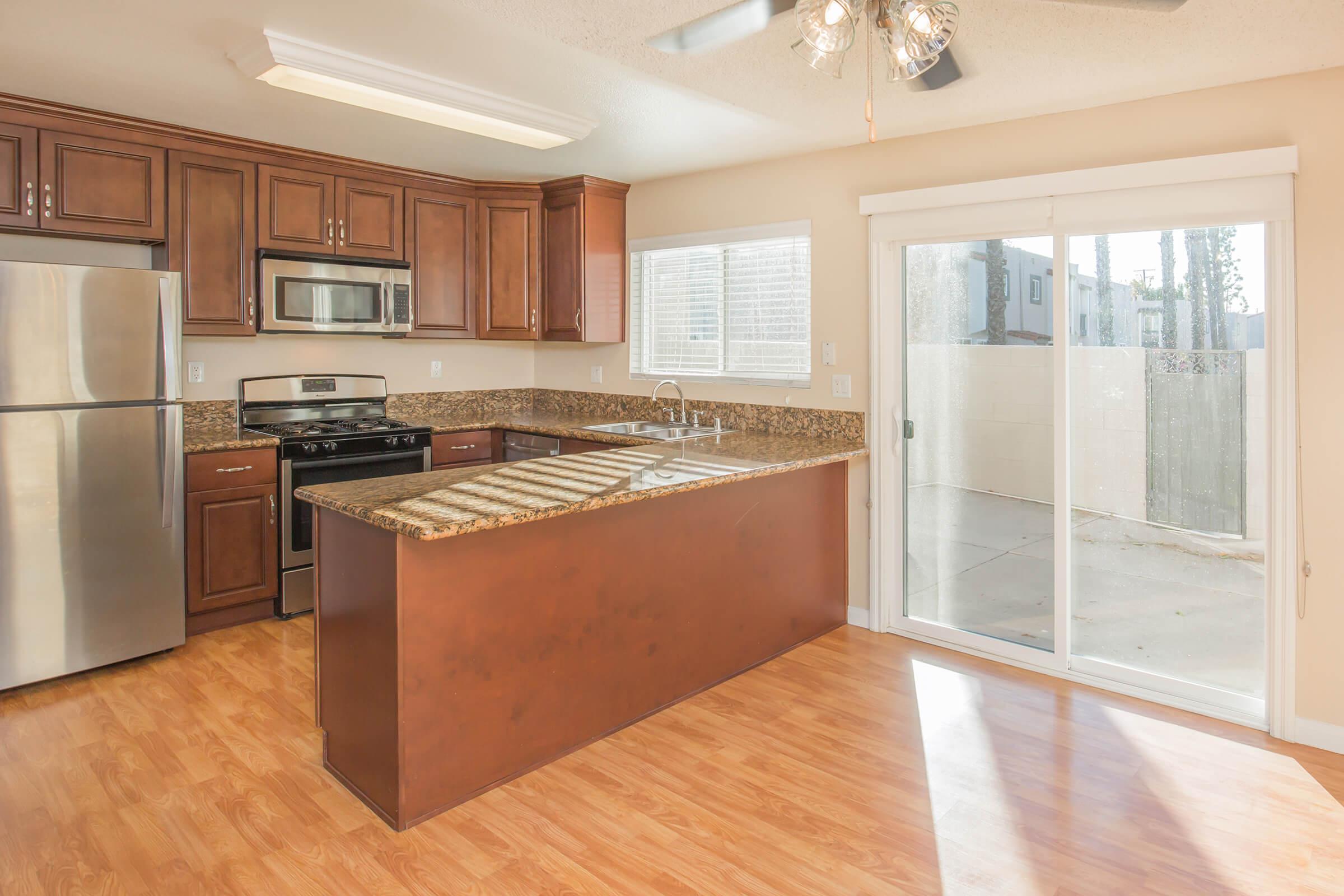 a modern kitchen with stainless steel appliances and wooden cabinets