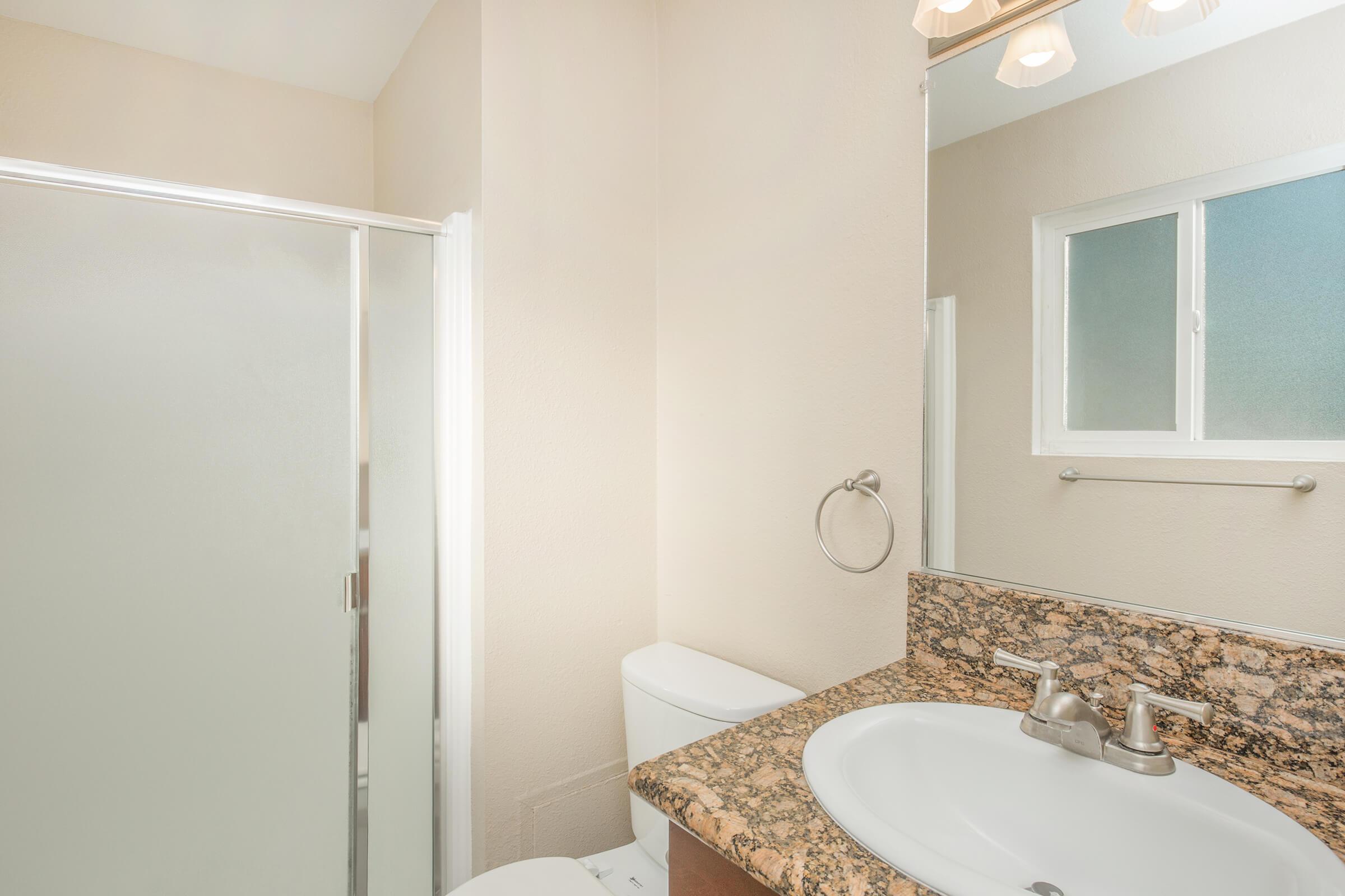 a white sink sitting under a mirror