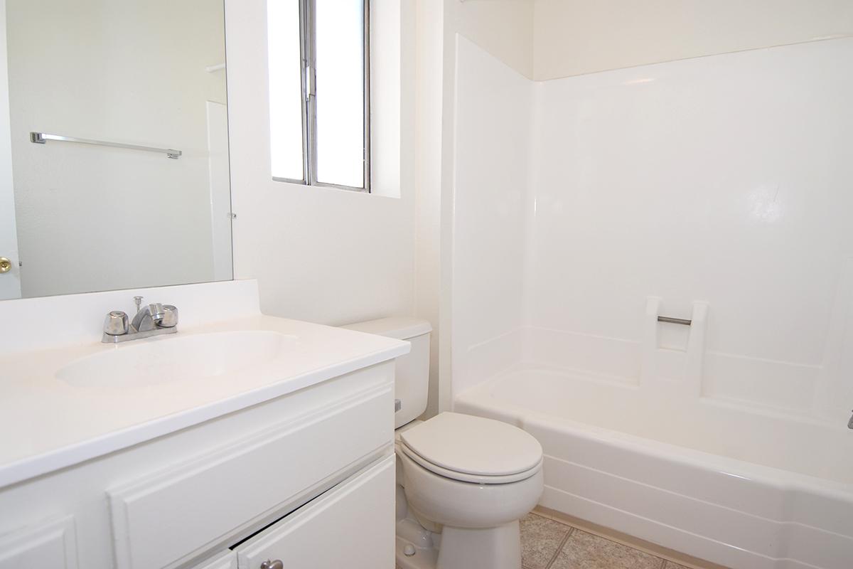 a white sink sitting under a mirror