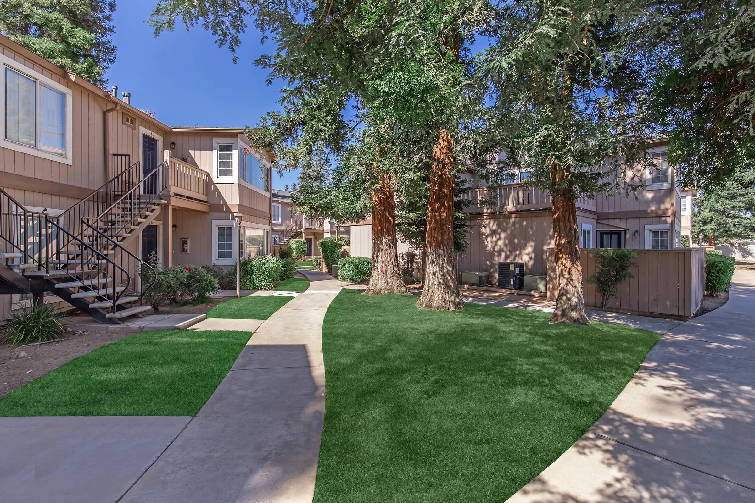 a house with a lawn in front of a brick building