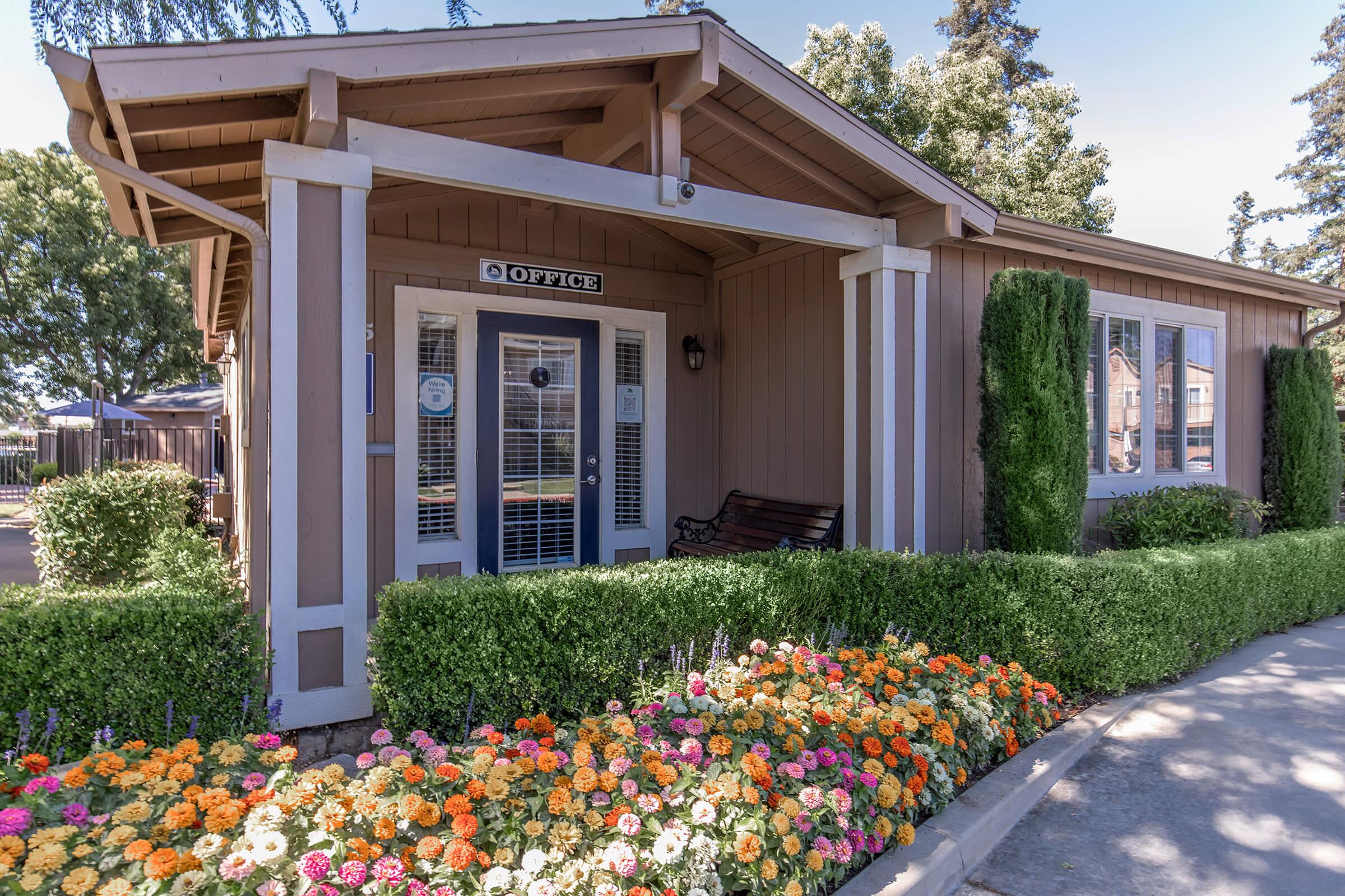 a close up of a flower garden in front of a house