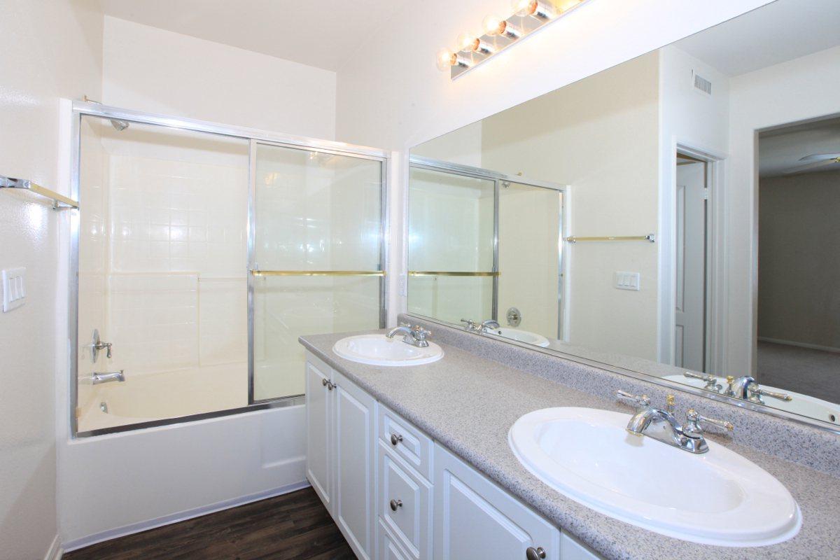 a white sink sitting under a mirror