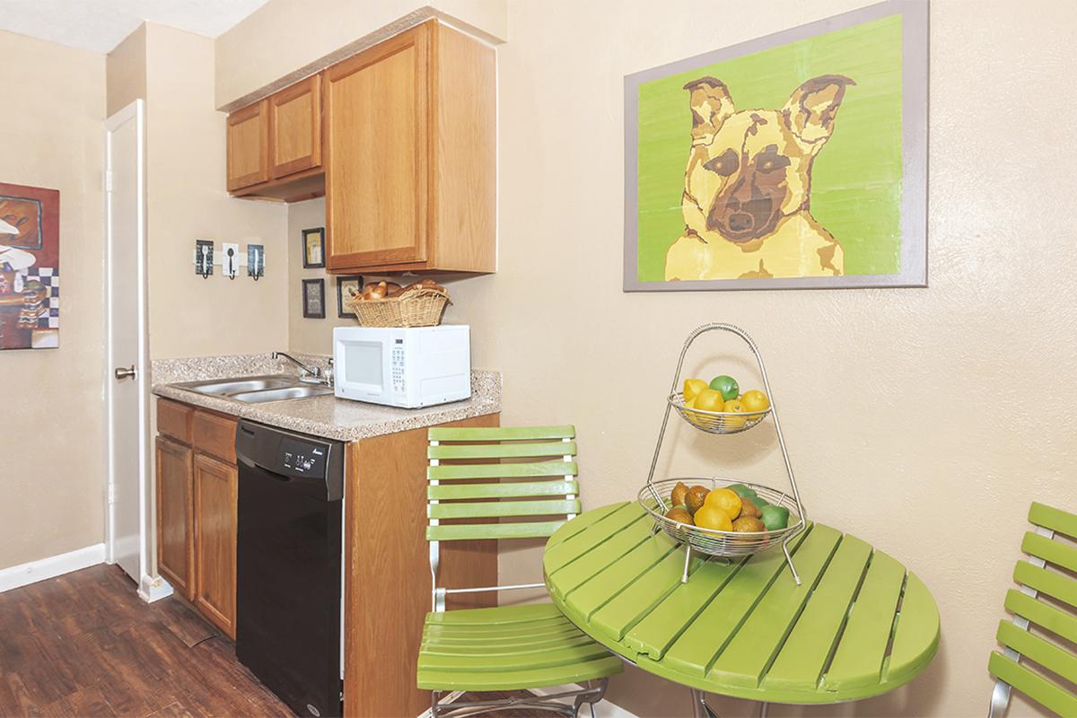 a kitchen with wooden cabinets and a dining table