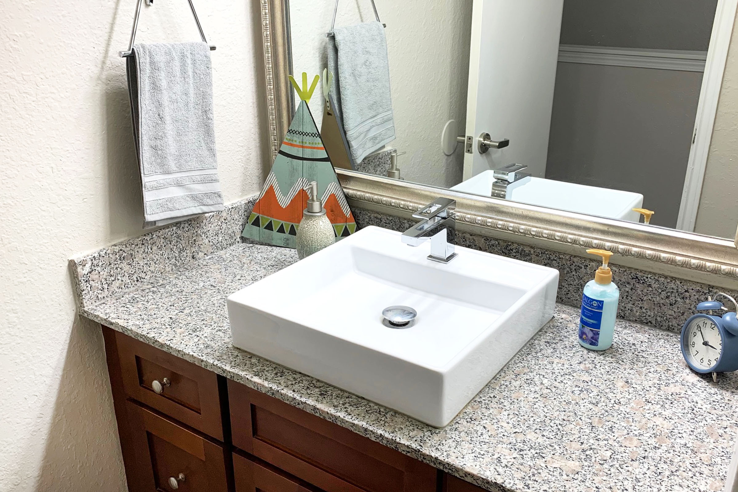 a counter with a sink and a mirror