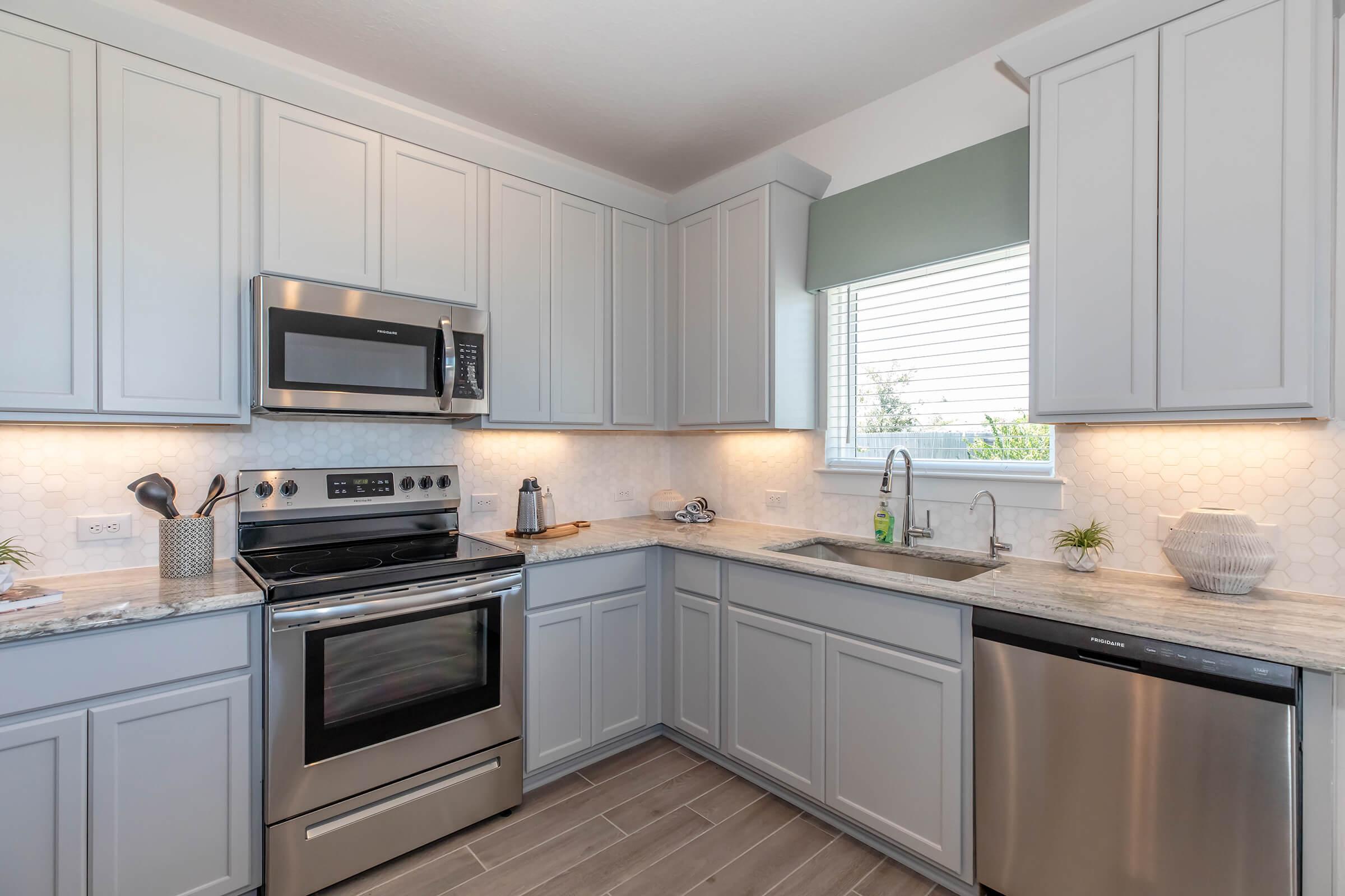 a kitchen with a stove a sink and a microwave