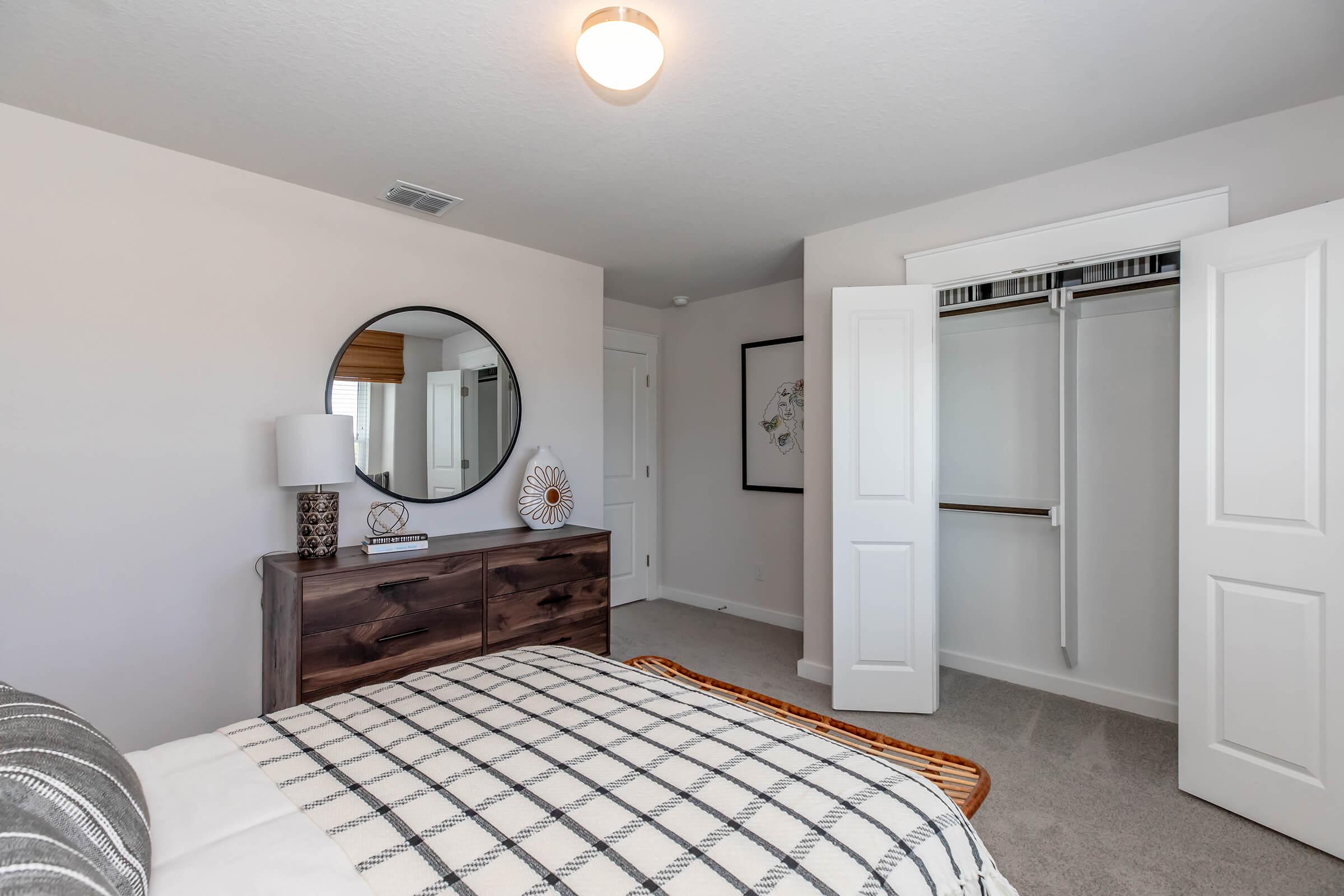 a bedroom with a bed and desk in a room