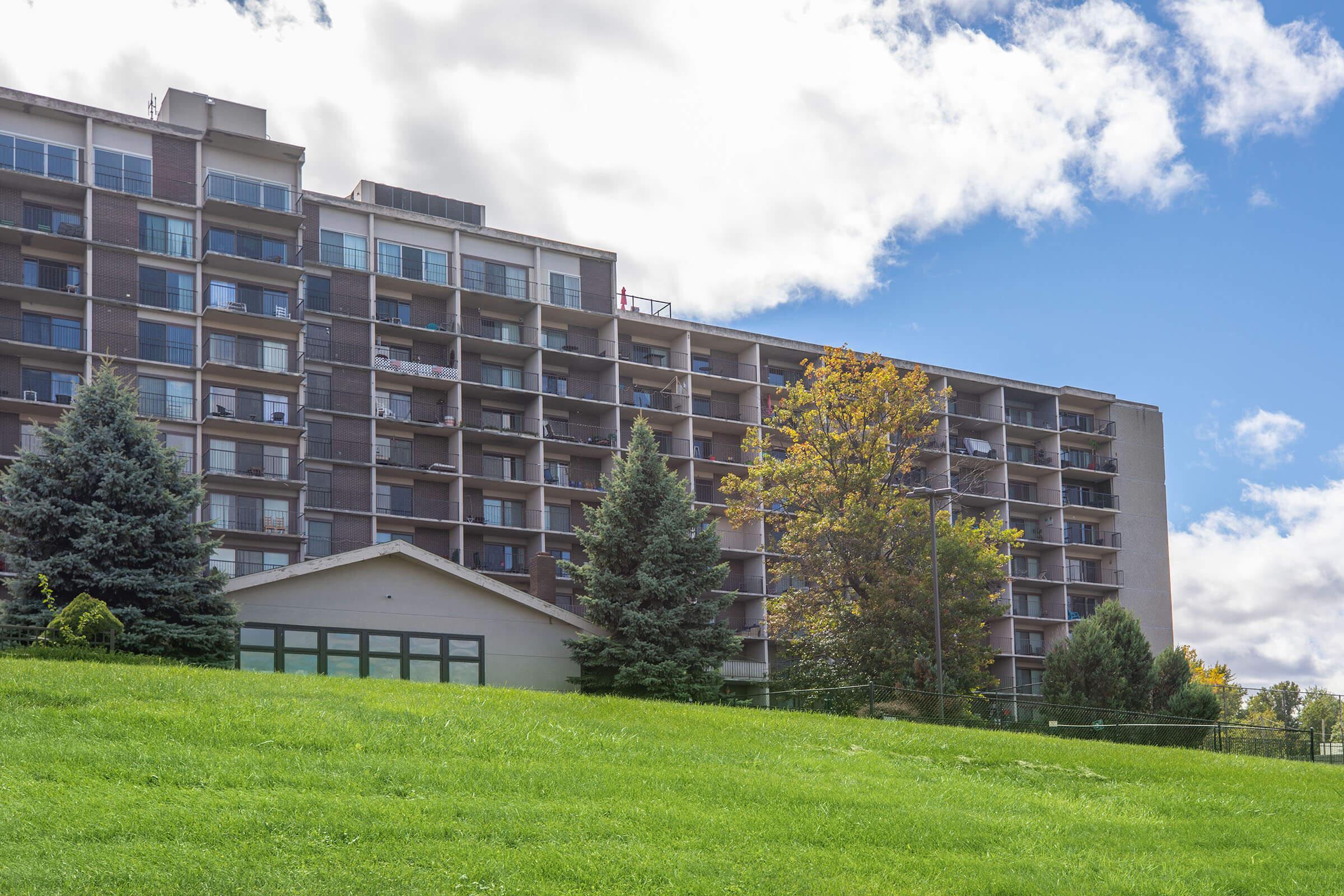 a large brick building with a grassy field