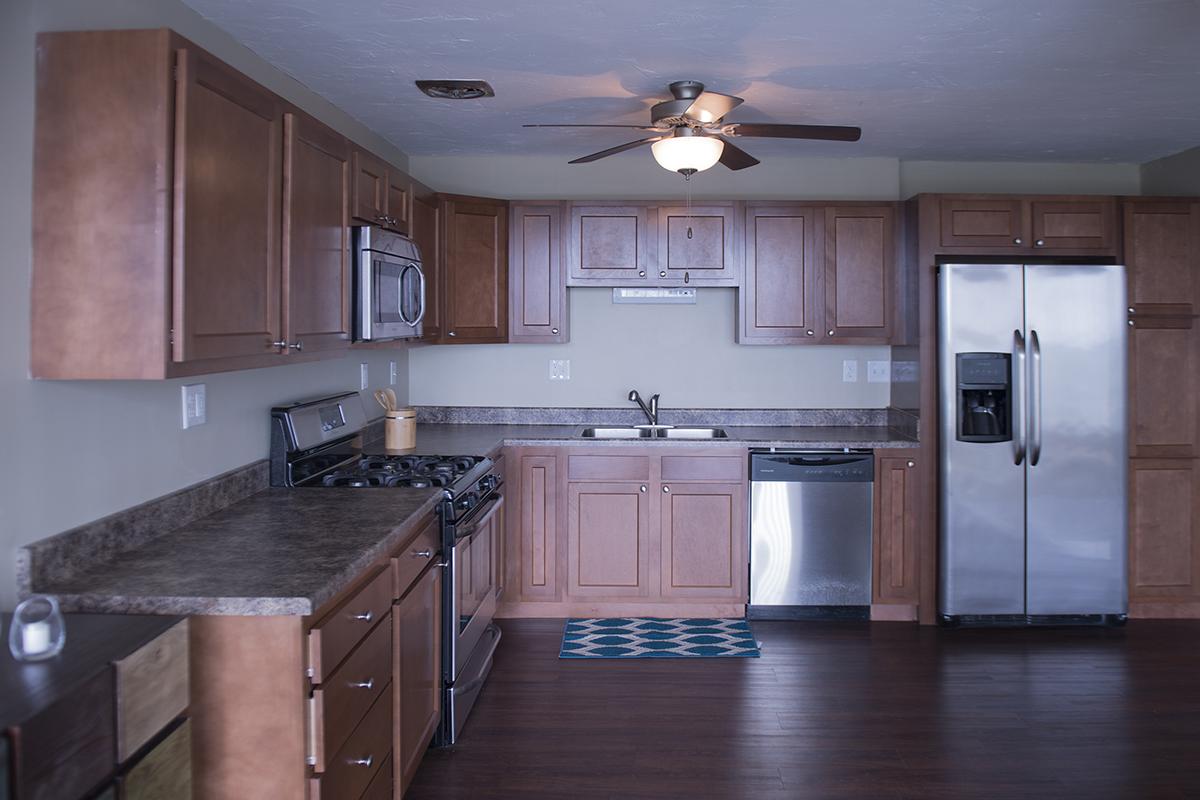 a large kitchen with stainless steel appliances and wooden cabinets