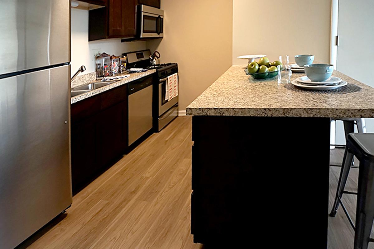 a modern kitchen with stainless steel appliances and wooden cabinets