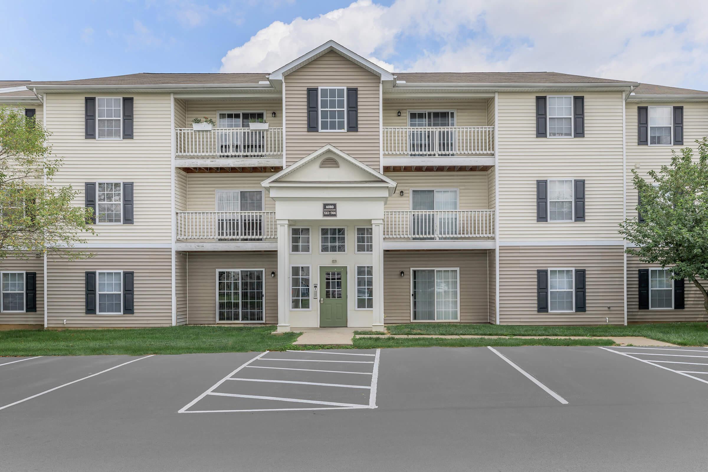 a large empty parking lot in front of a house