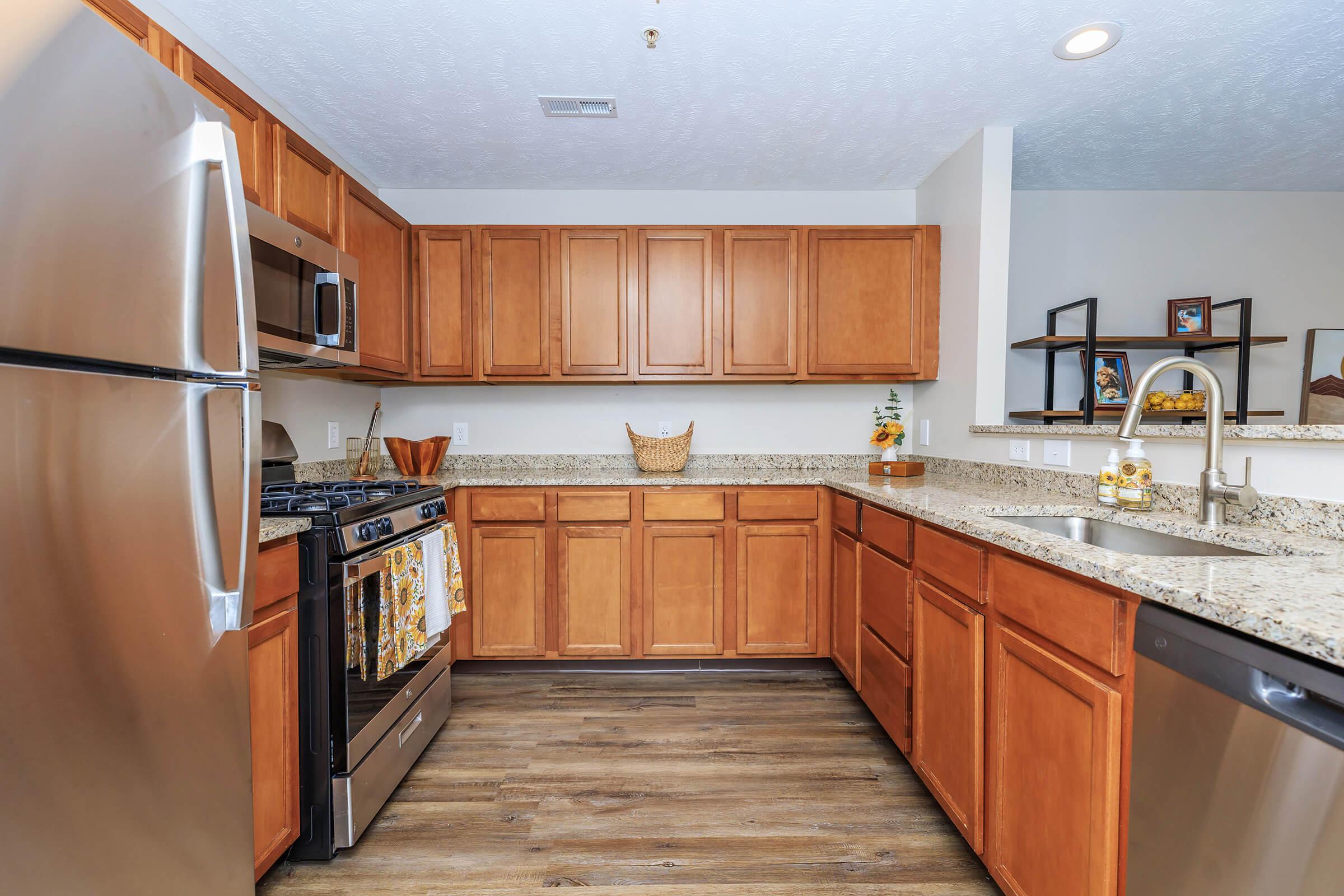 a large kitchen with stainless steel appliances and wooden cabinets