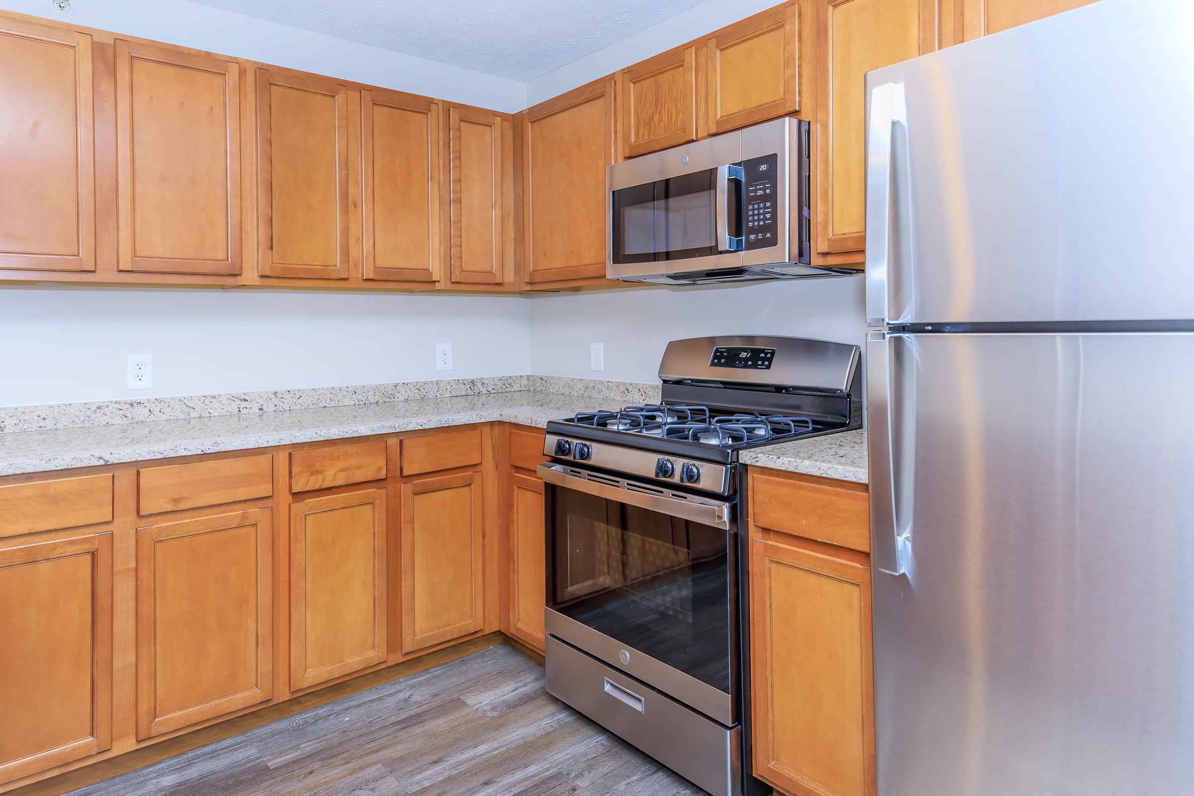 a kitchen with stainless steel appliances and wooden cabinets