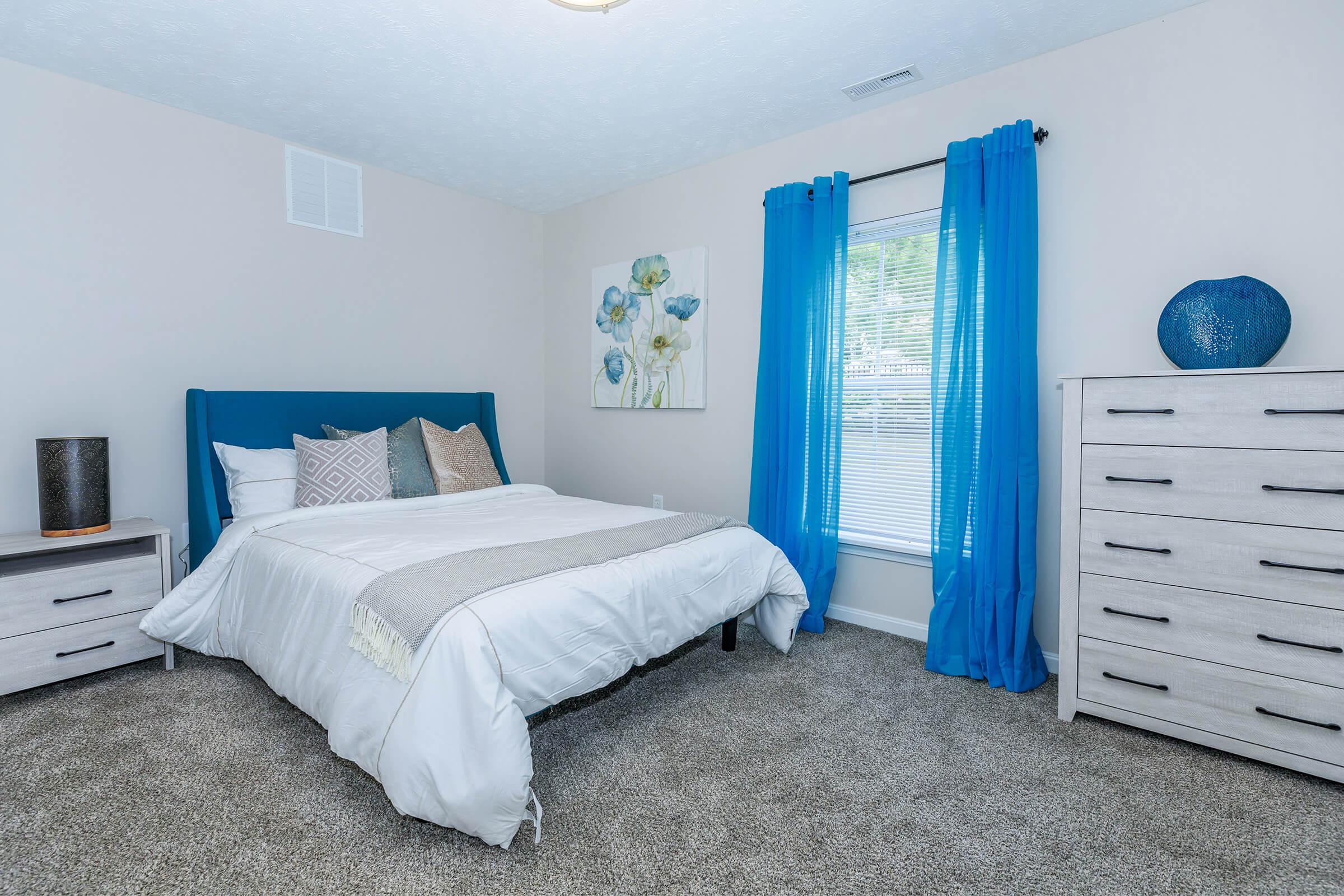 a bedroom with a bed and desk in a room