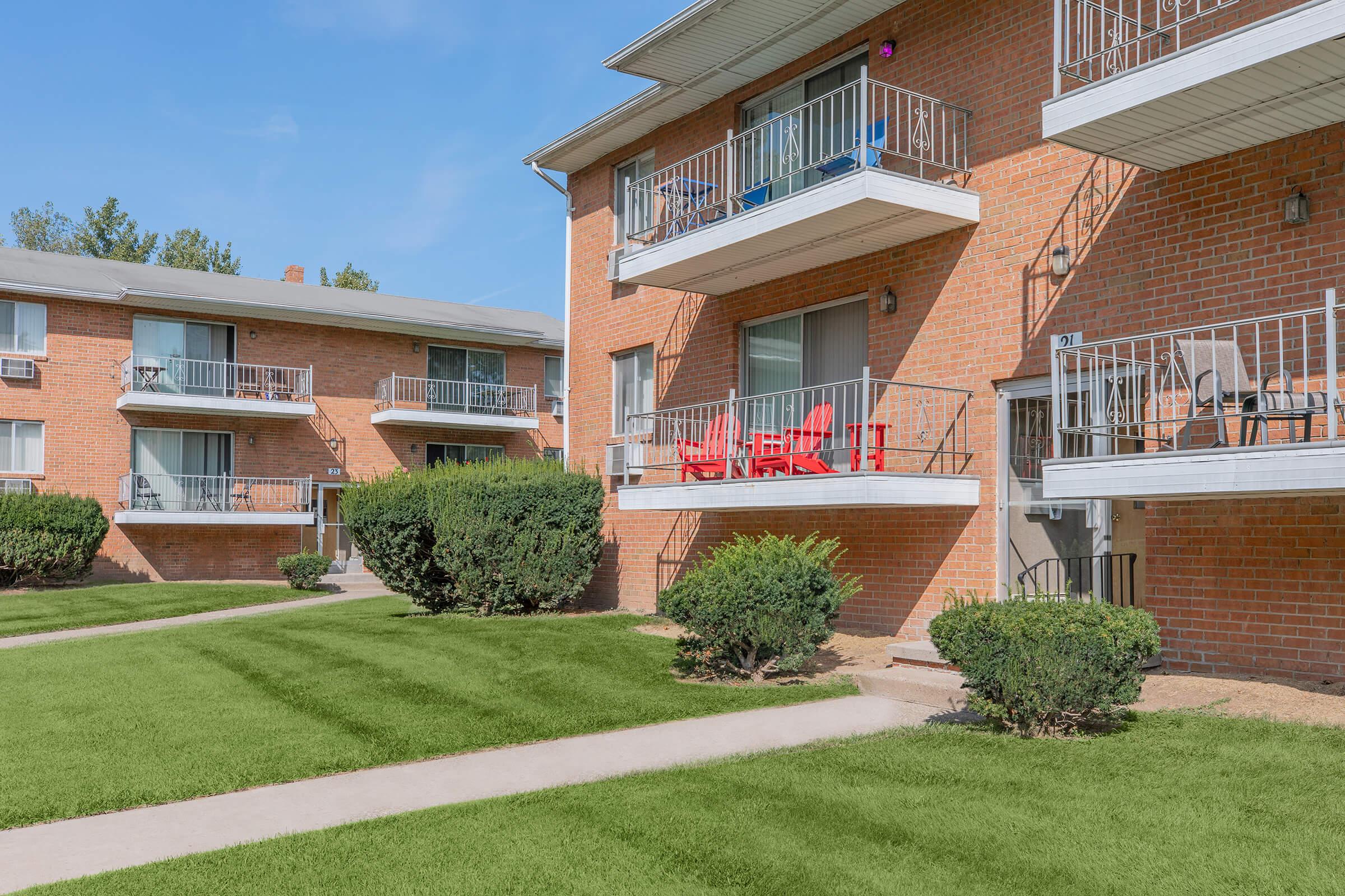 a house with a lawn in front of a brick building