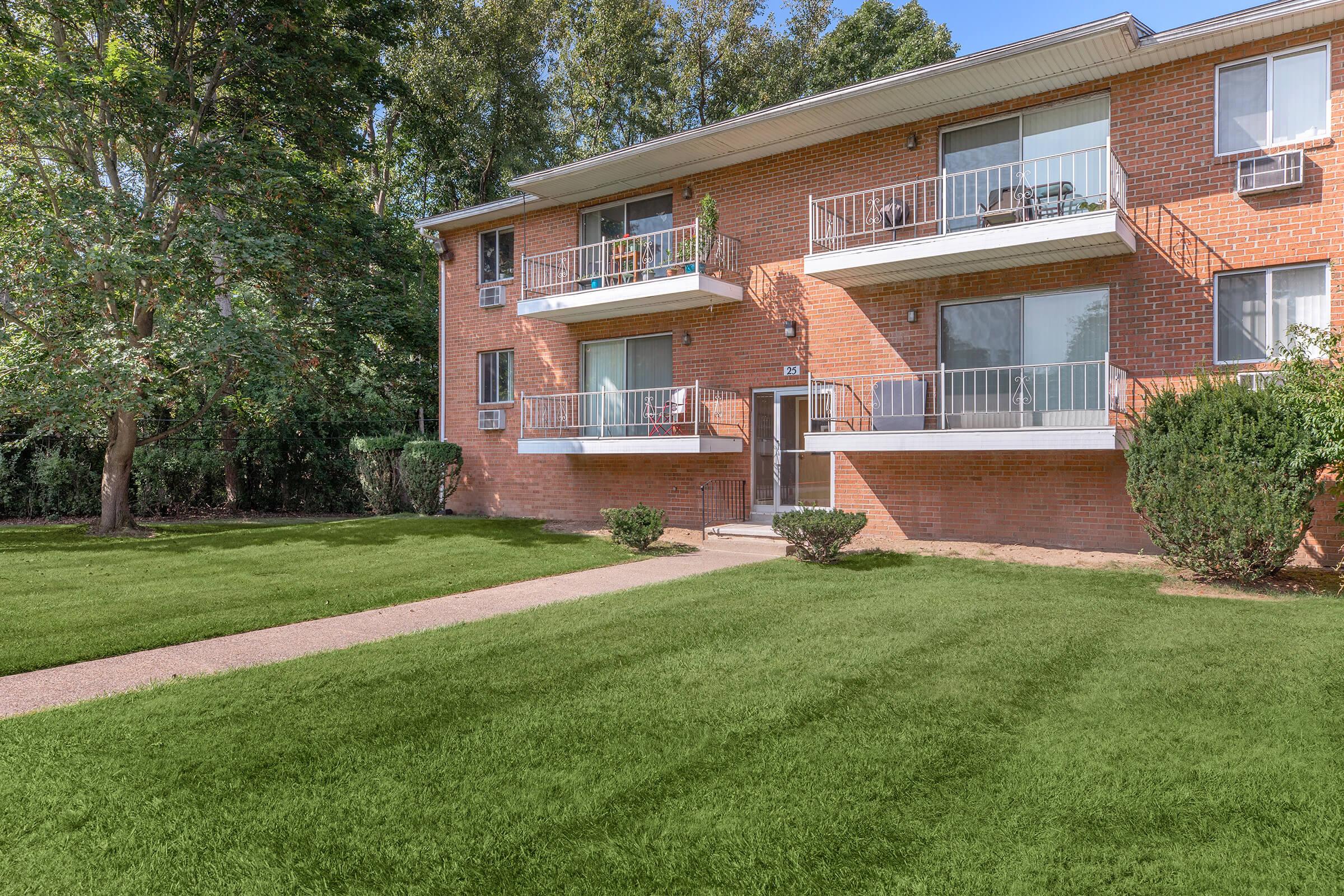 a house with a lawn in front of a brick building