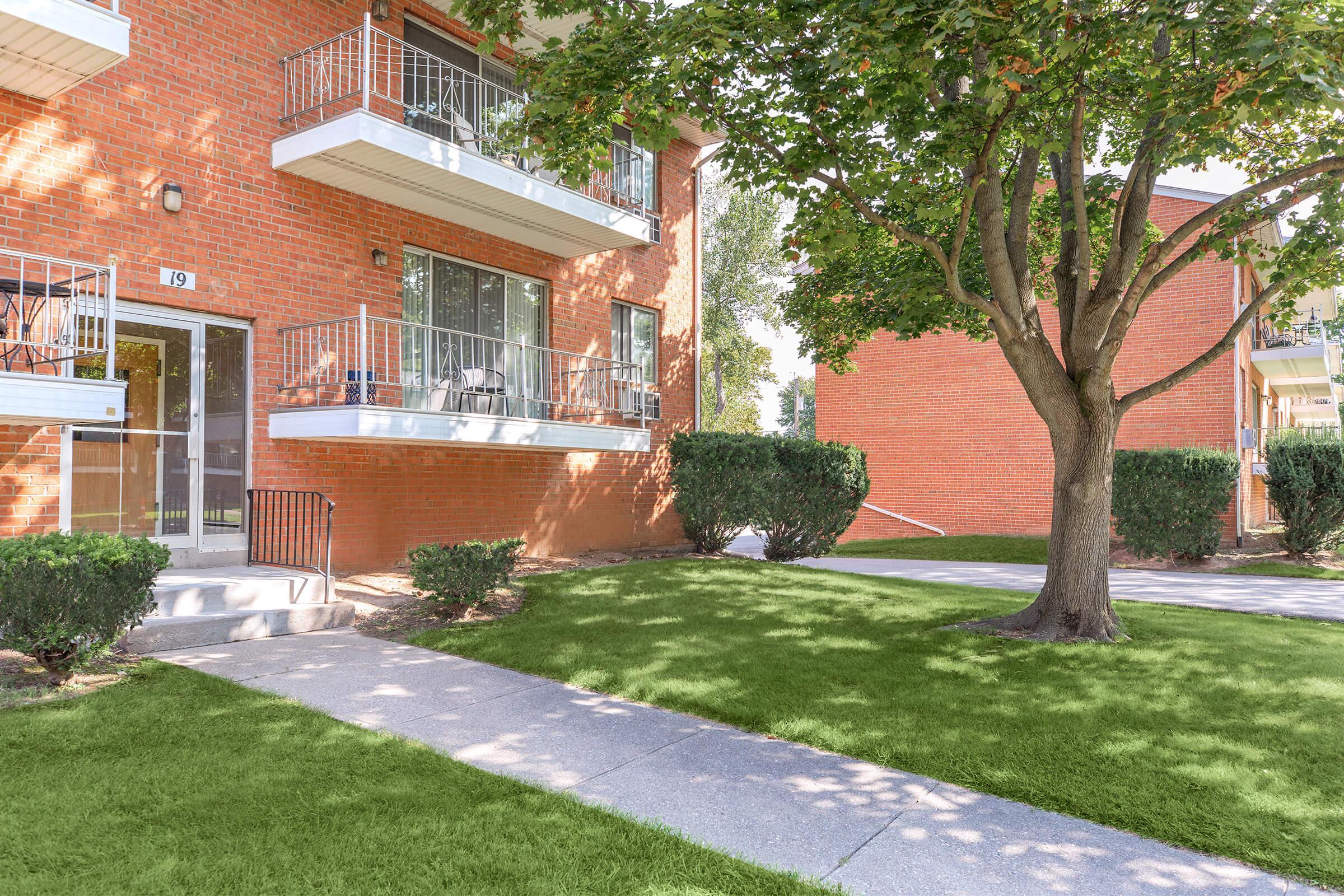 a house with a lawn in front of a brick building