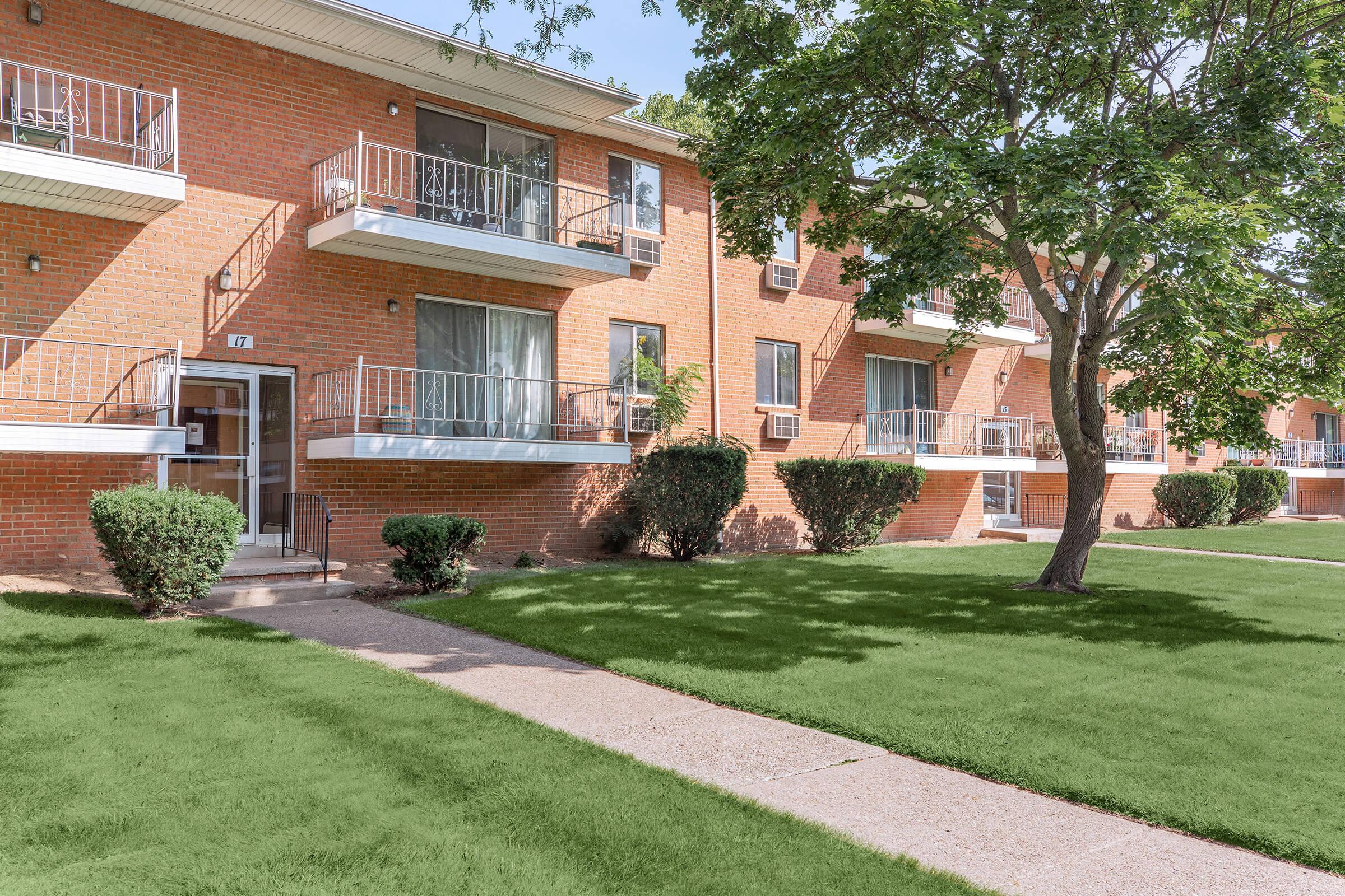 a house with a lawn in front of a brick building