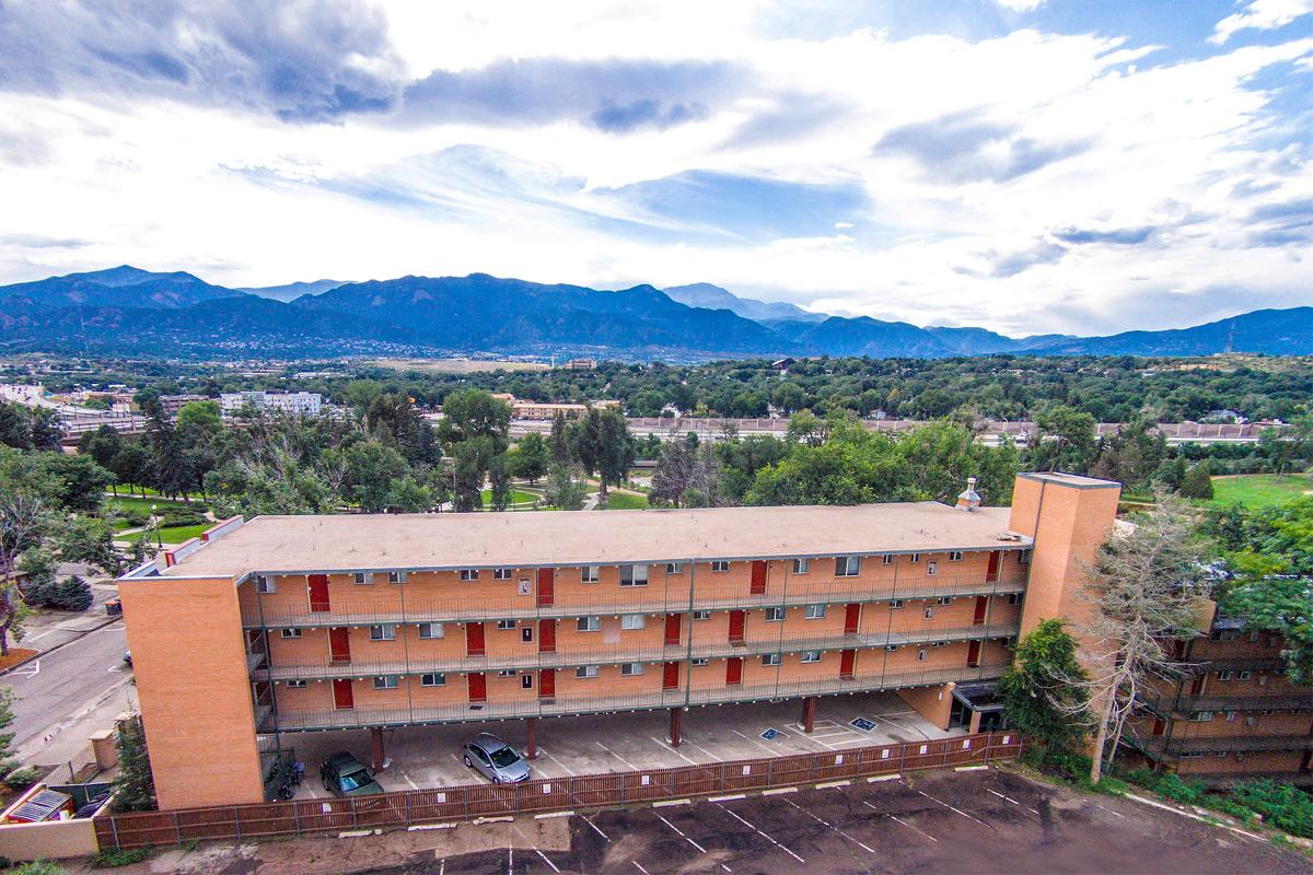 a large brick building with a mountain in the background