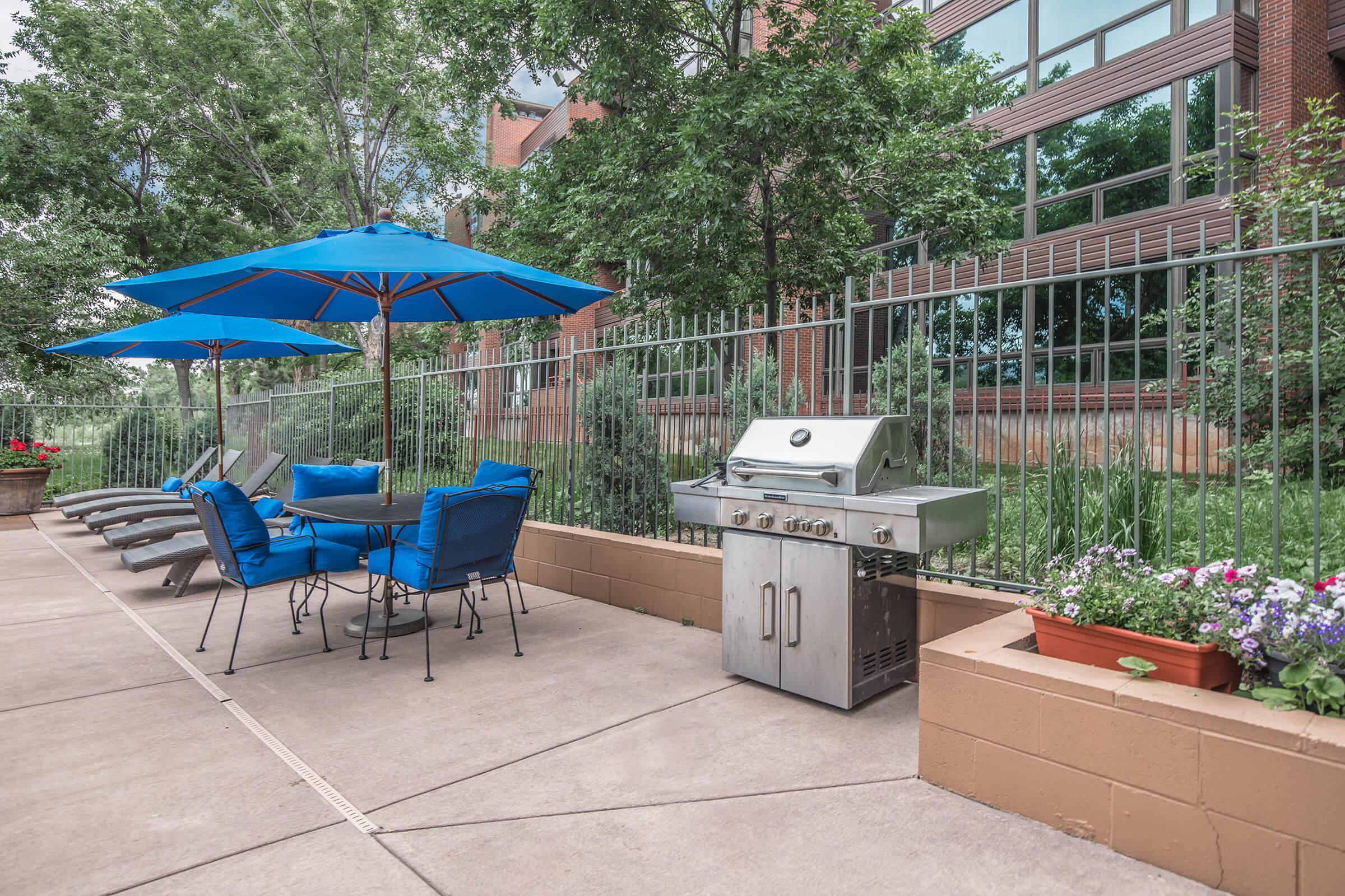 a group of lawn chairs sitting on top of a blue umbrella