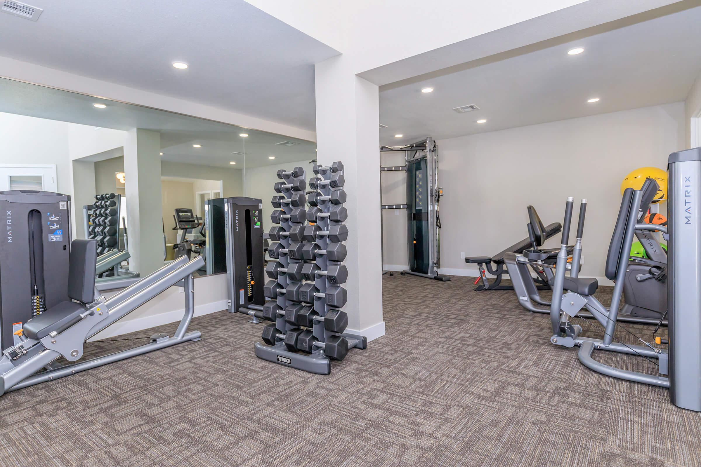 Modern clean fitness center gym with work out equipment and weight set