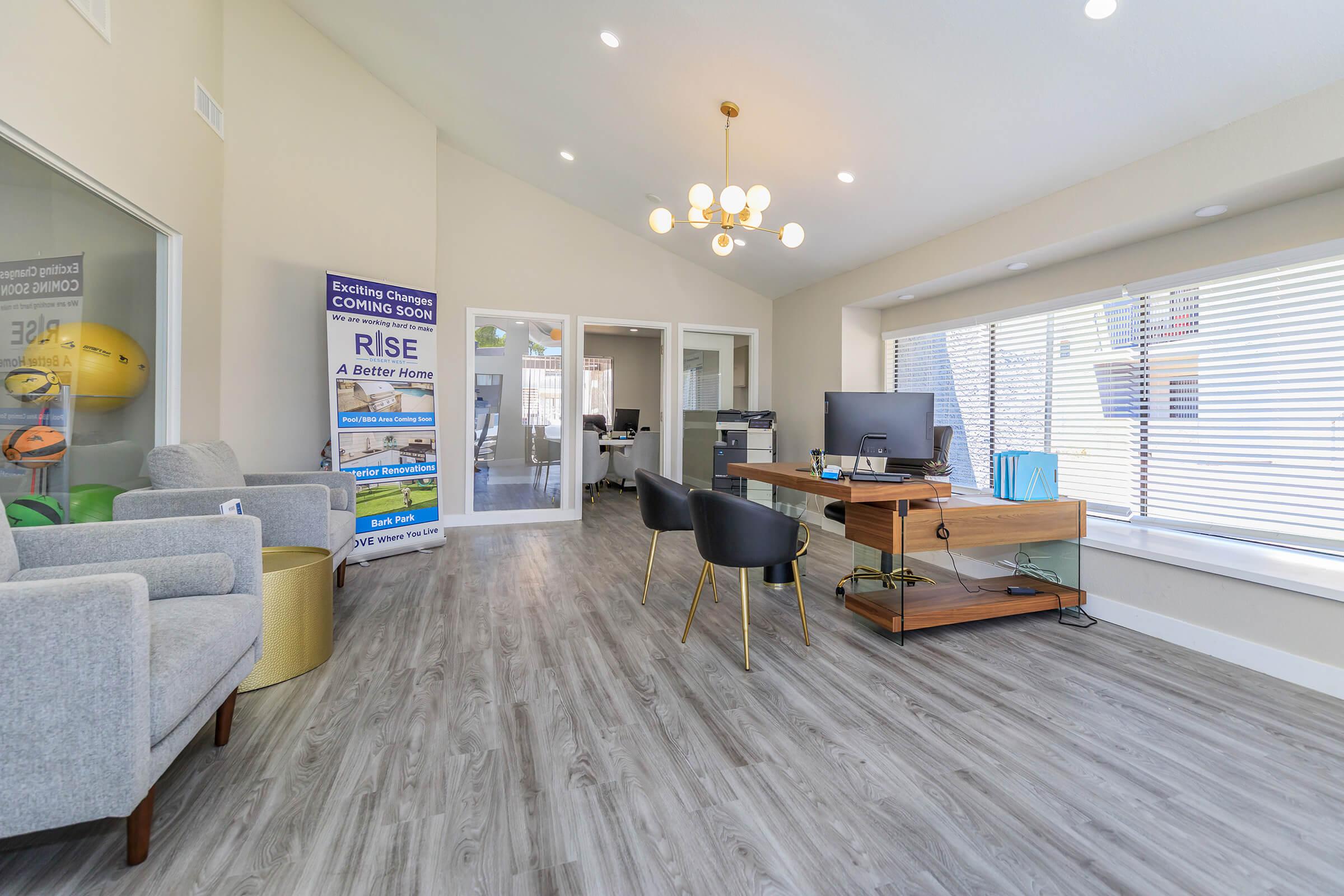Inside Rise Desert West's apartment leasing office with a sitting area and office desks