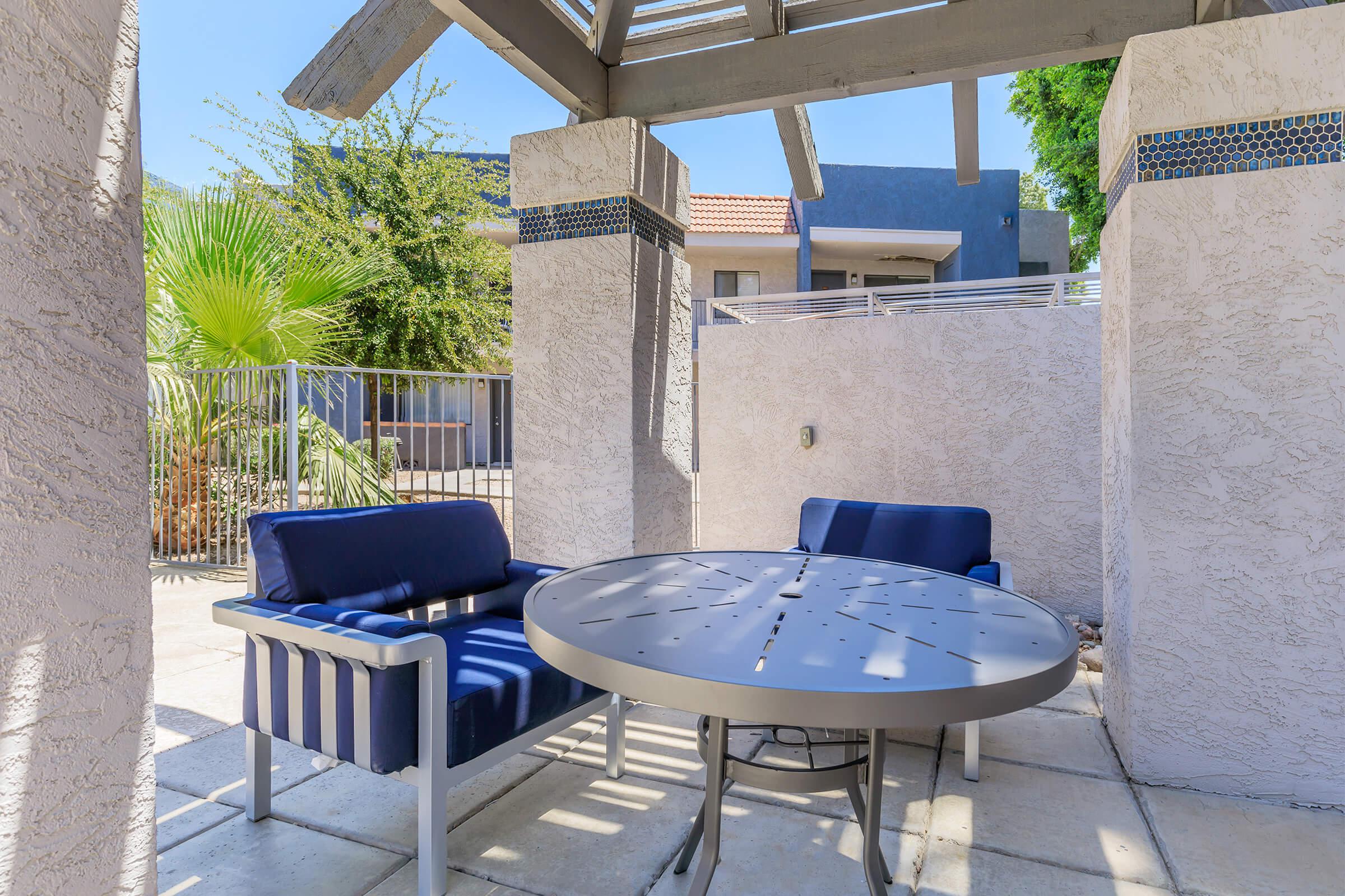 Shaded seating area and table near the Phoenix apartment outdoor pool