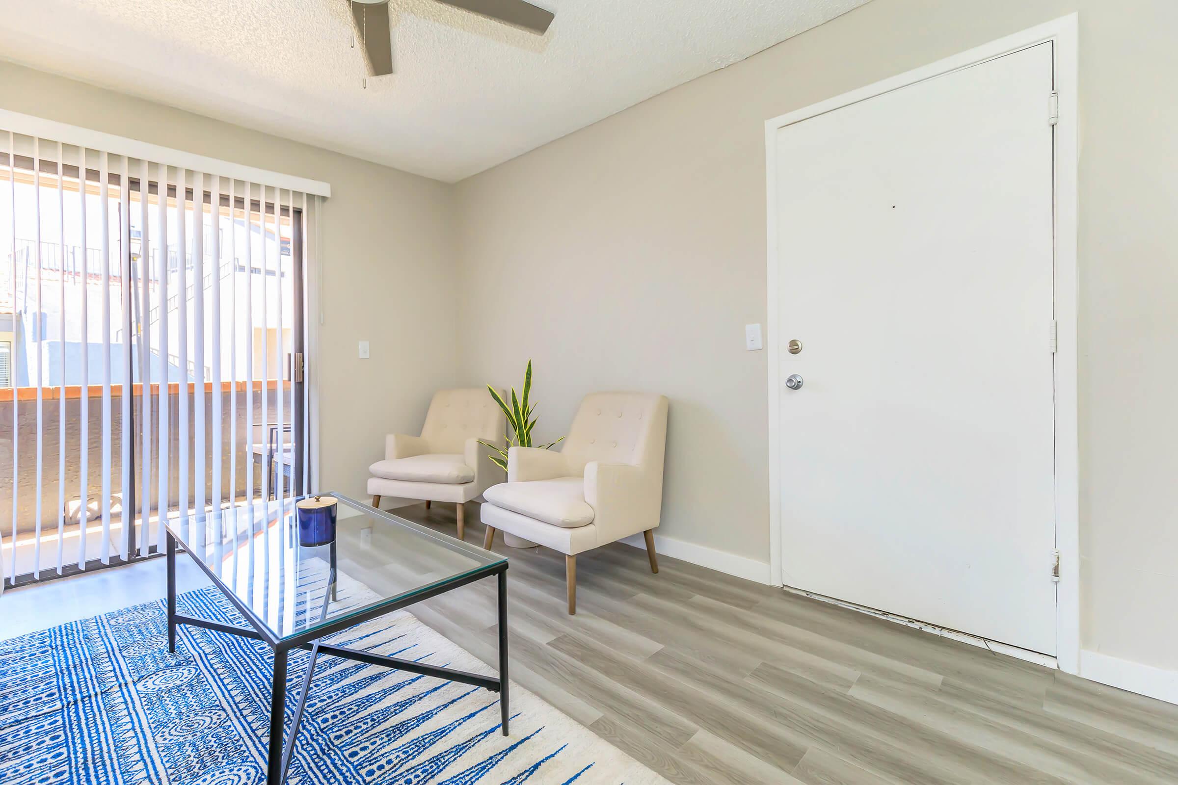 Apartment entryway leading into a bright and modern living room with large sliding glass doors