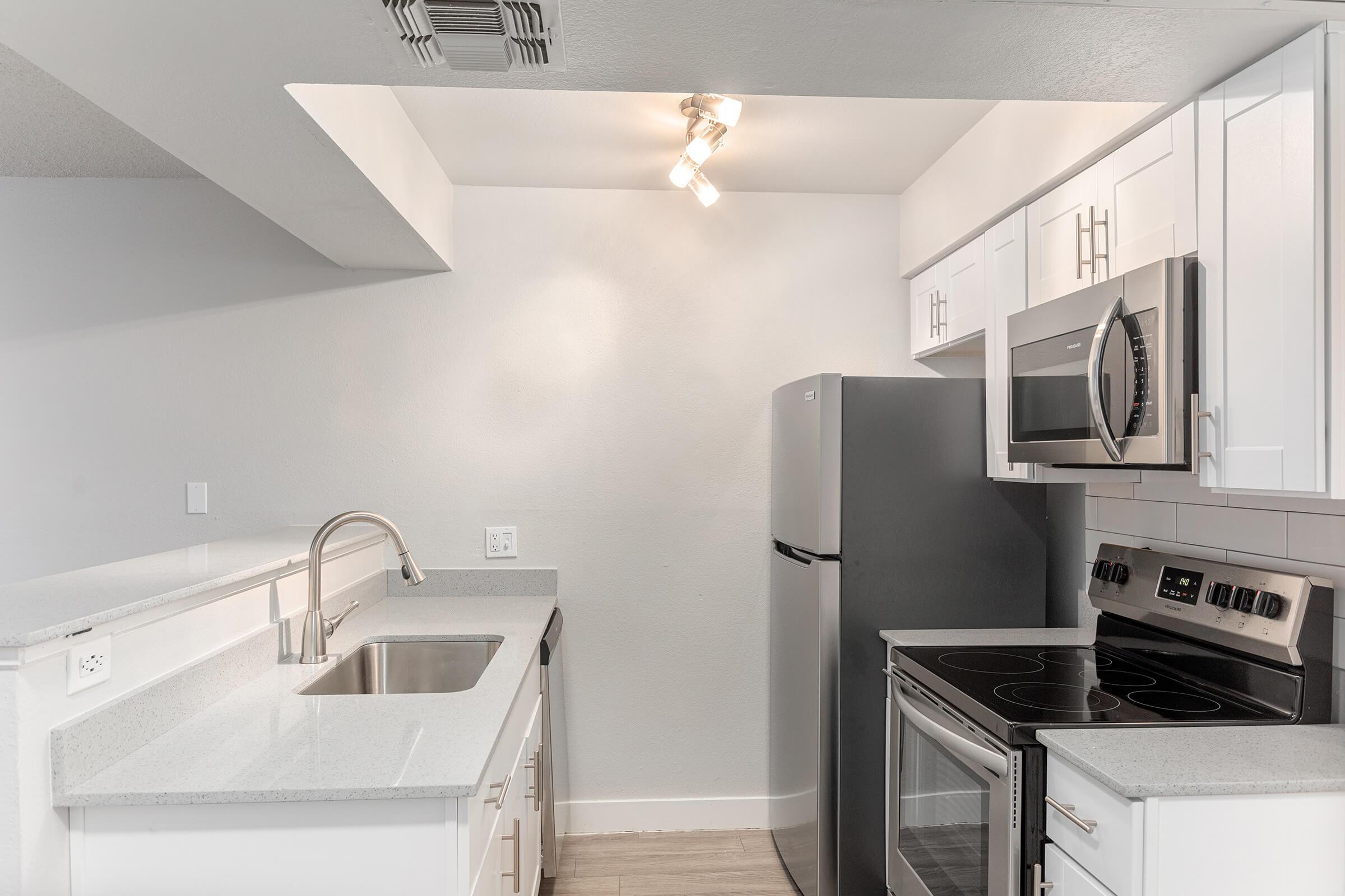 Galley way kitchen with stainless steel appliance and white cabinets