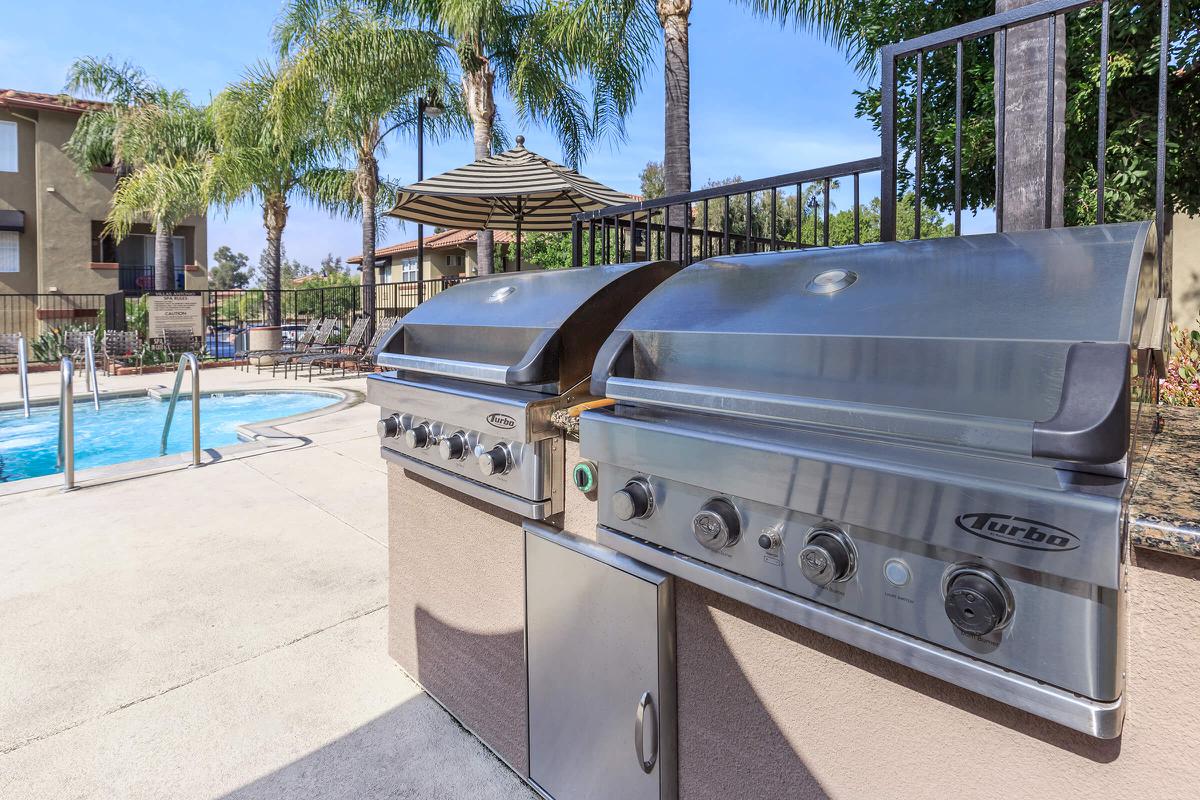 Stainless steel barbecues next to the community pool